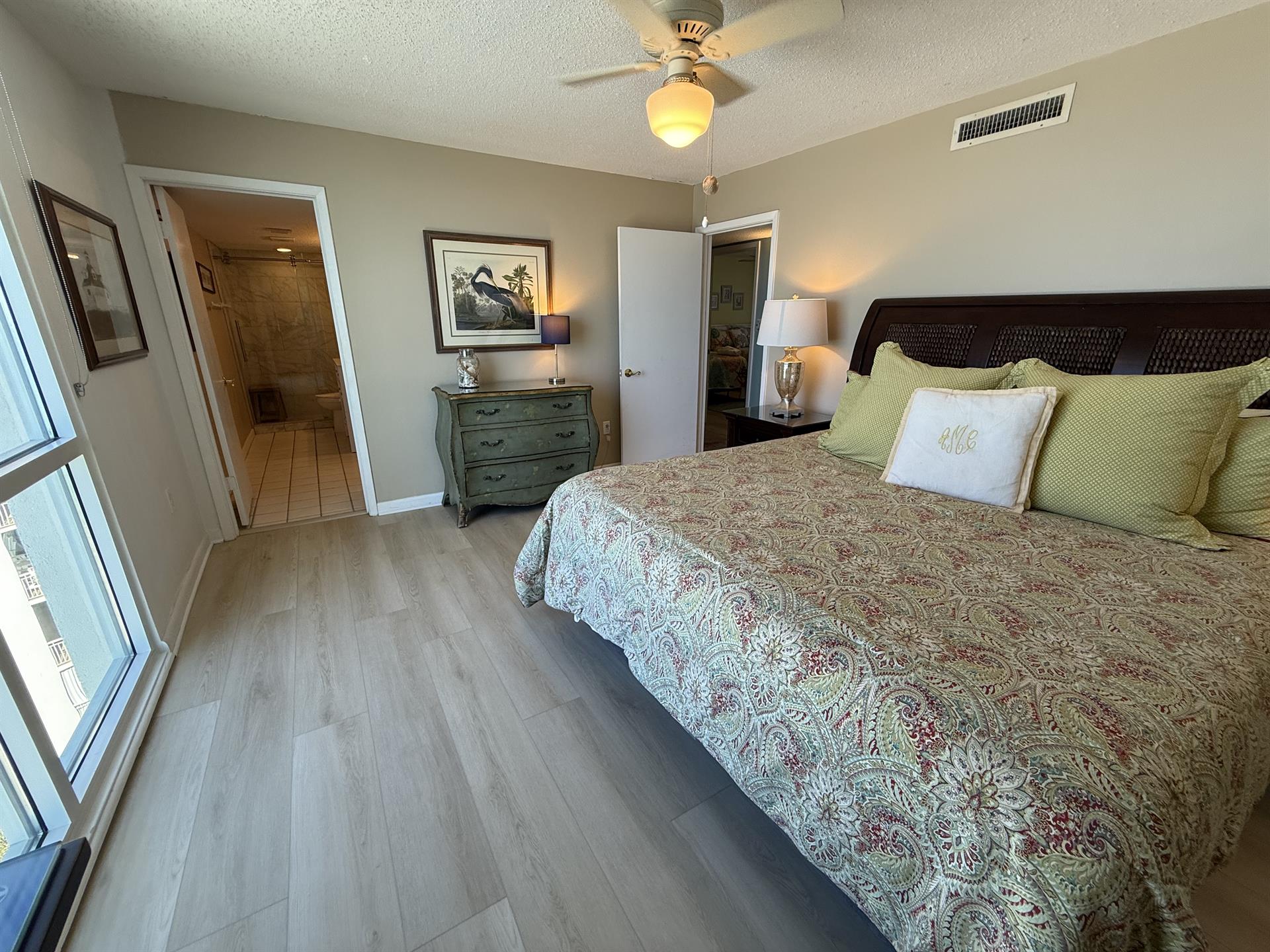 Drift into peaceful sleep in your elegant bedroom with coastal charm, complete with a ceiling fan and en-suite bathroom access.