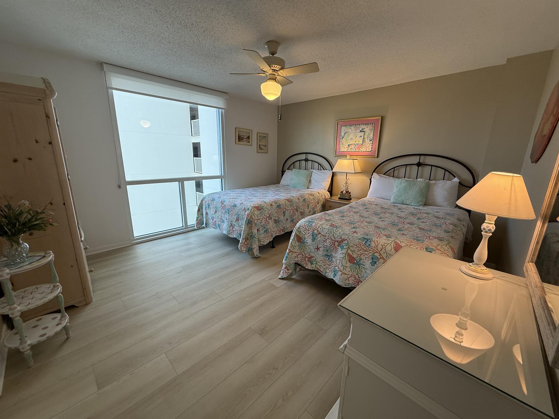 Rest peacefully in your comfortable double bedroom with ocean views through floor-to-ceiling windows and gentle ceiling fan for perfect climate.