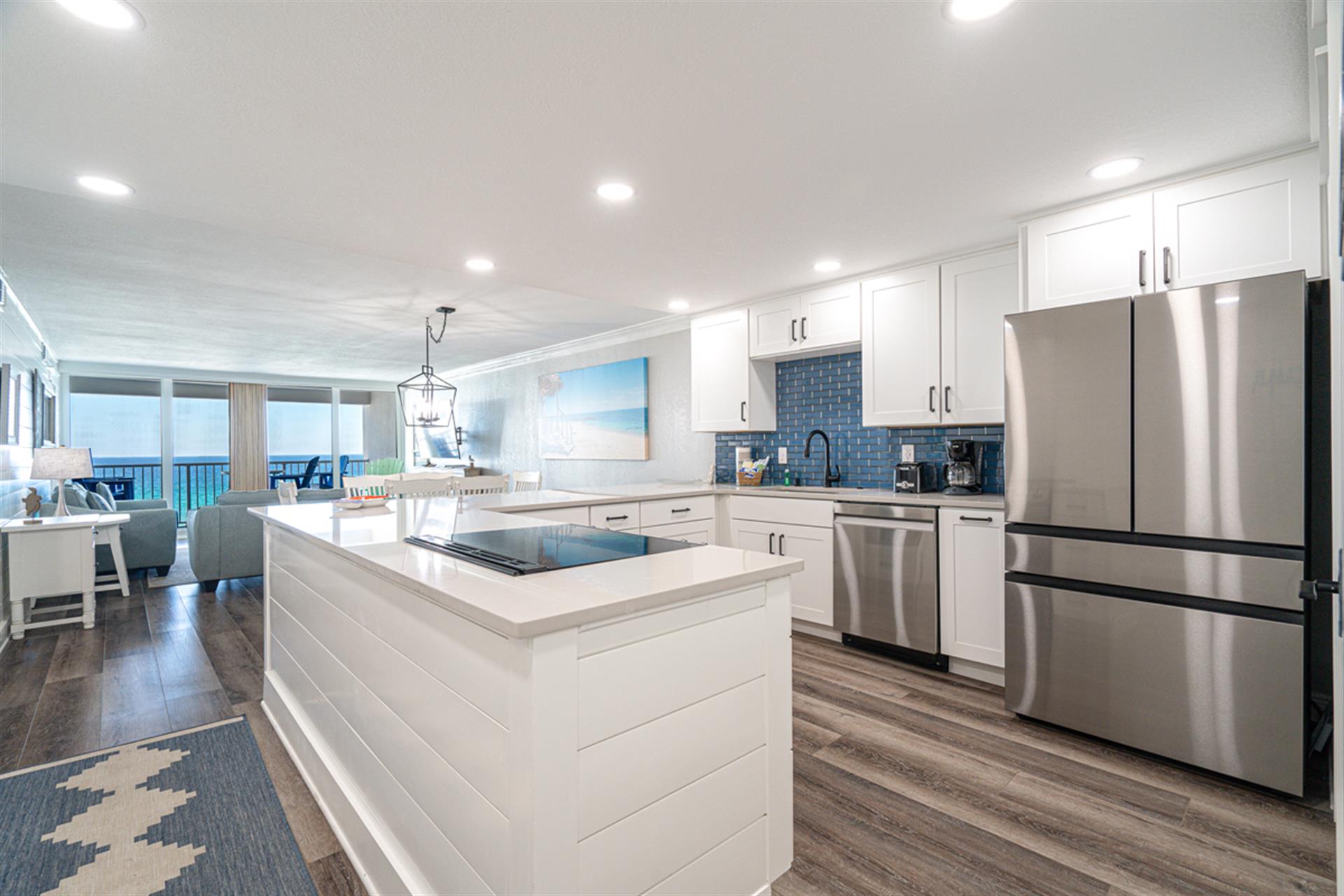 Your gourmet kitchen features sleek white cabinetry, stainless steel appliances, and a spacious island where you can cook while enjoying stunning ocean views.