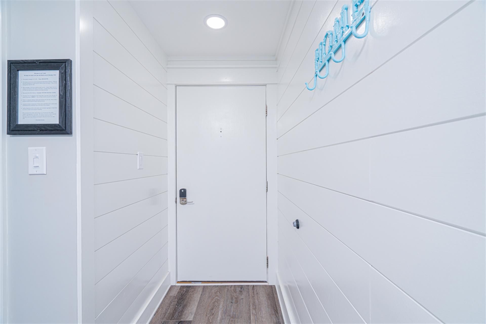 Step into your coastal retreat through this bright, welcoming entryway with charming shiplap walls and cheerful nautical touches.