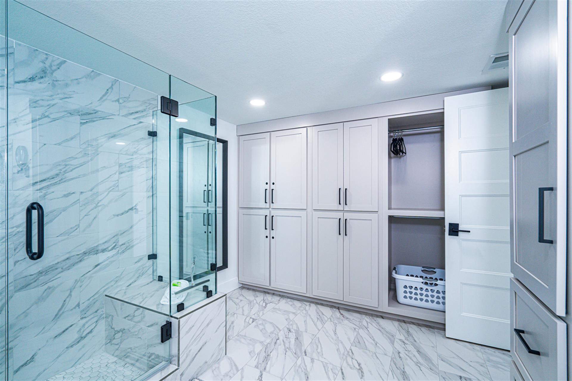 Your luxurious marble bathroom features a spacious glass shower, built-in wardrobes, and washer-dryer for ultimate convenience.