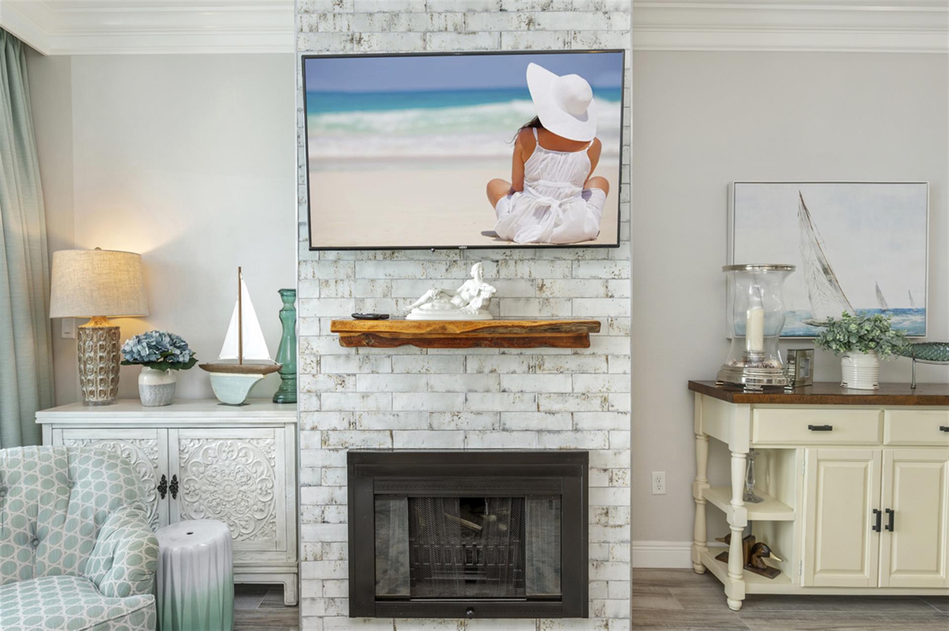 Relax in your serene living space where coastal charm meets comfort, with a cozy fireplace and beach-inspired décor creating your perfect seaside retreat.