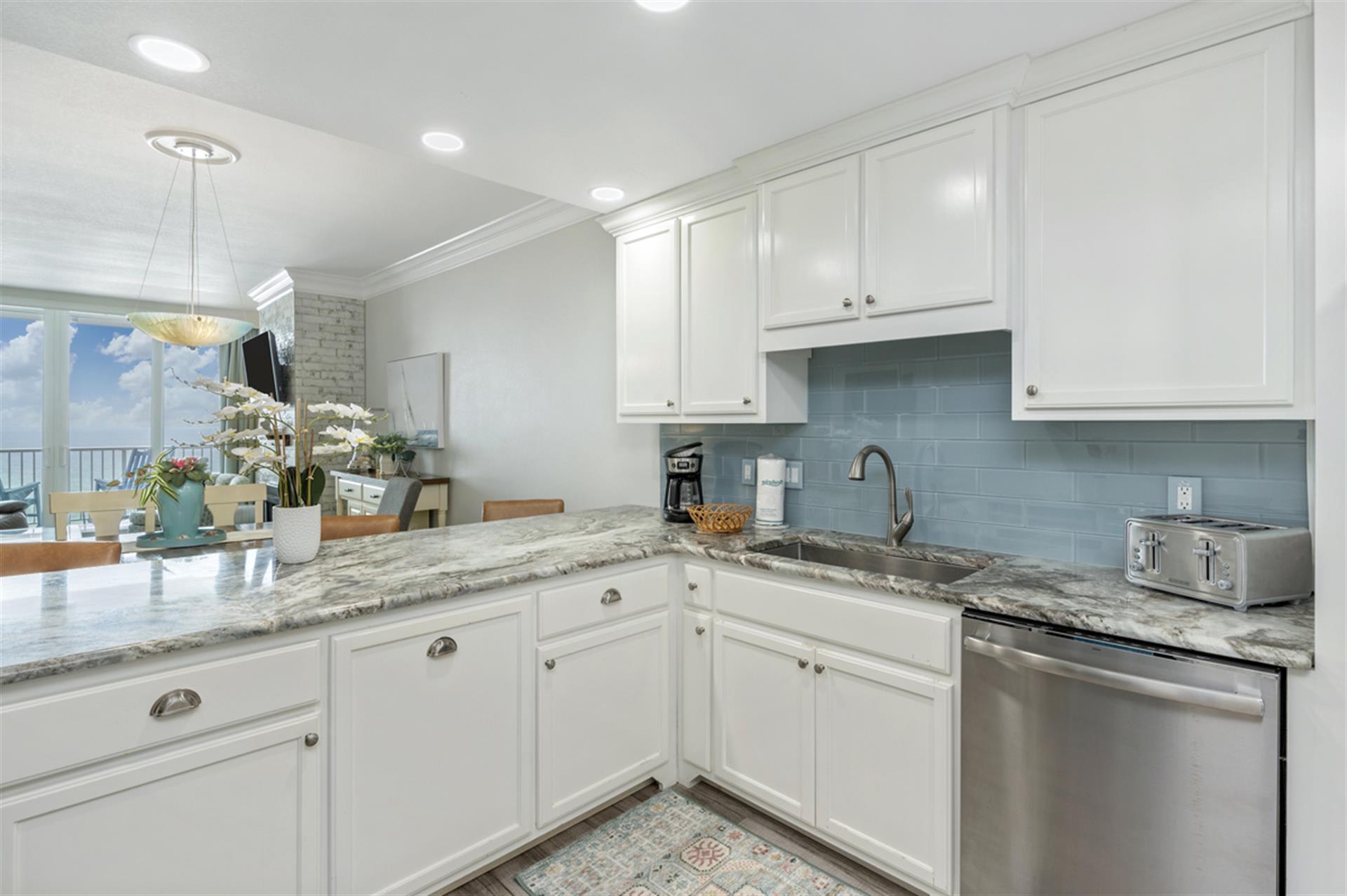 Your elegant kitchen features granite countertops, crisp white cabinets, and modern appliances—perfect for preparing memorable meals during your stay.