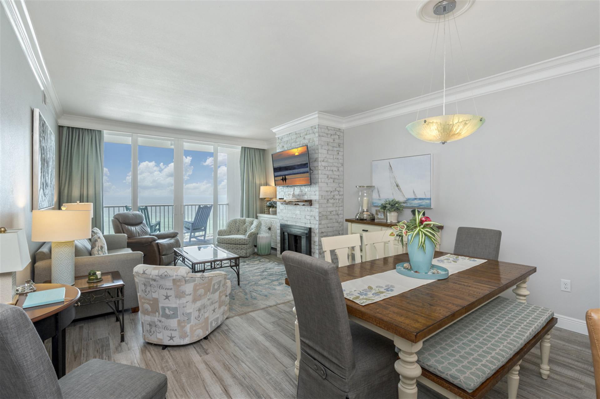 Relax in your elegant living space with ocean balcony access, cozy fireplace, and open dining area perfect for memorable meals.