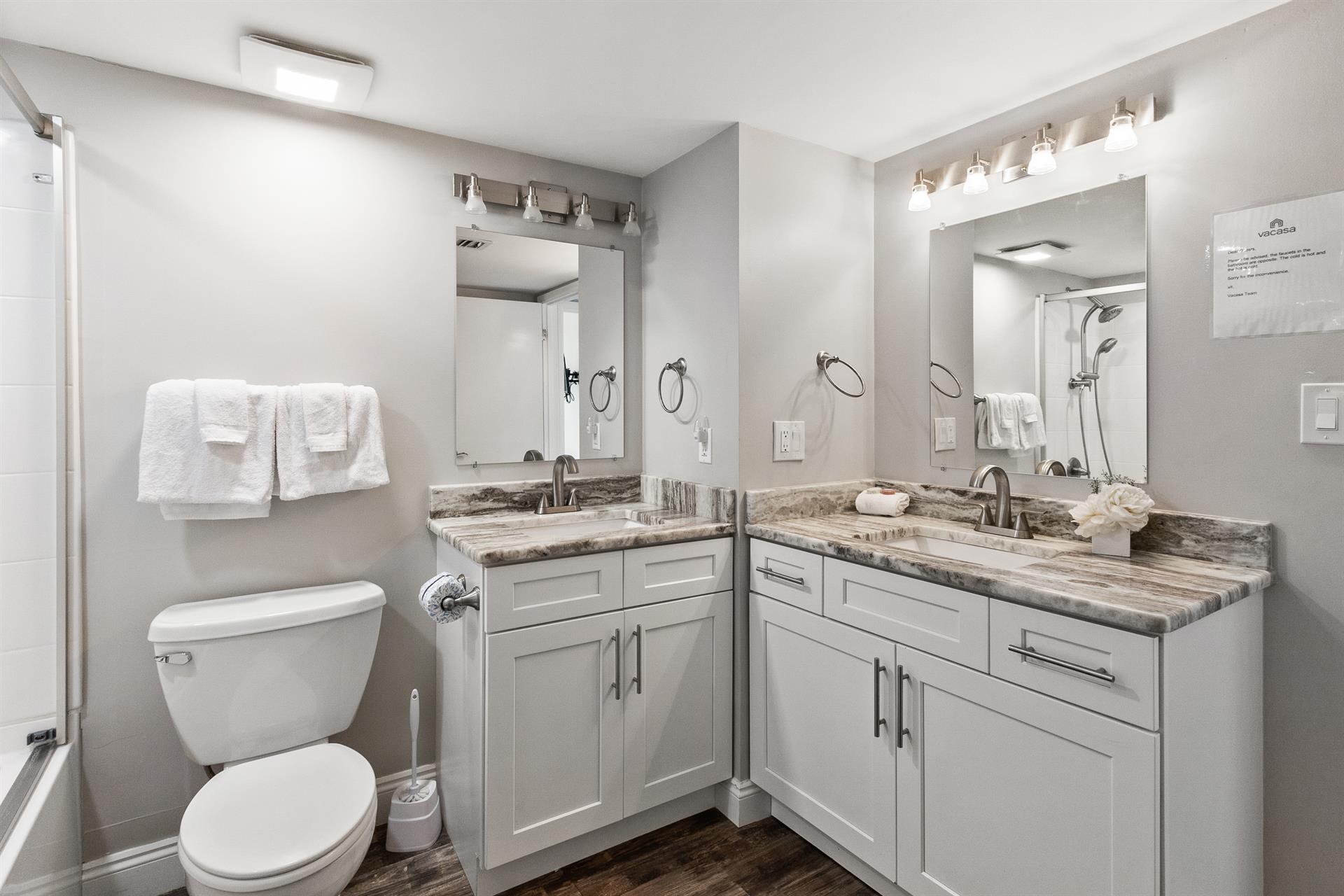 Pamper yourself in this luxurious bathroom with double vanities, marble countertops, and fresh white towels waiting for your arrival.