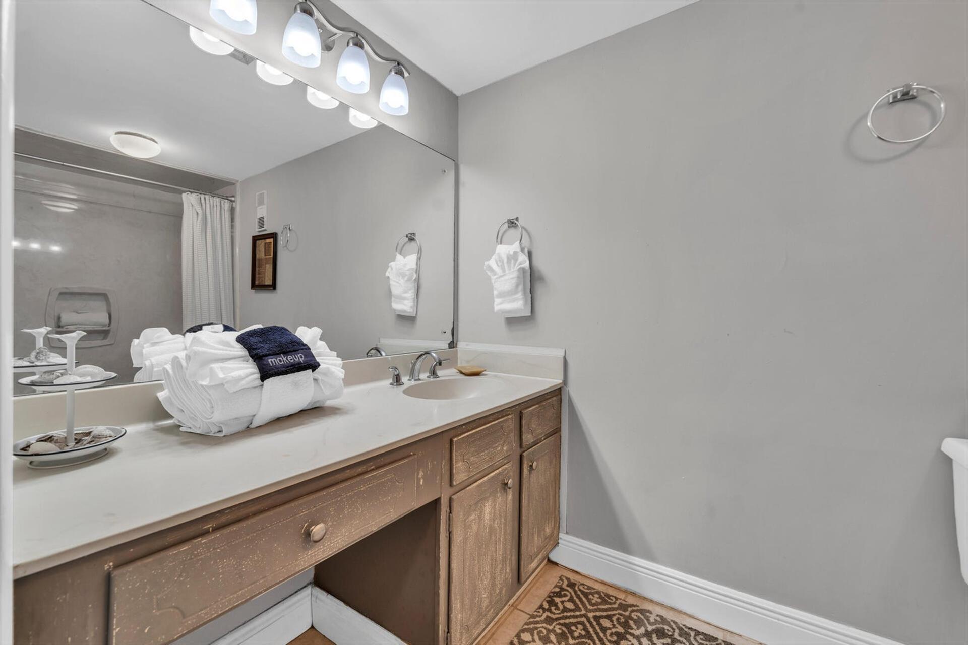 Your private bathroom features a spacious vanity with plenty of counter space, fresh towels, and bright vanity lighting for your morning routine.