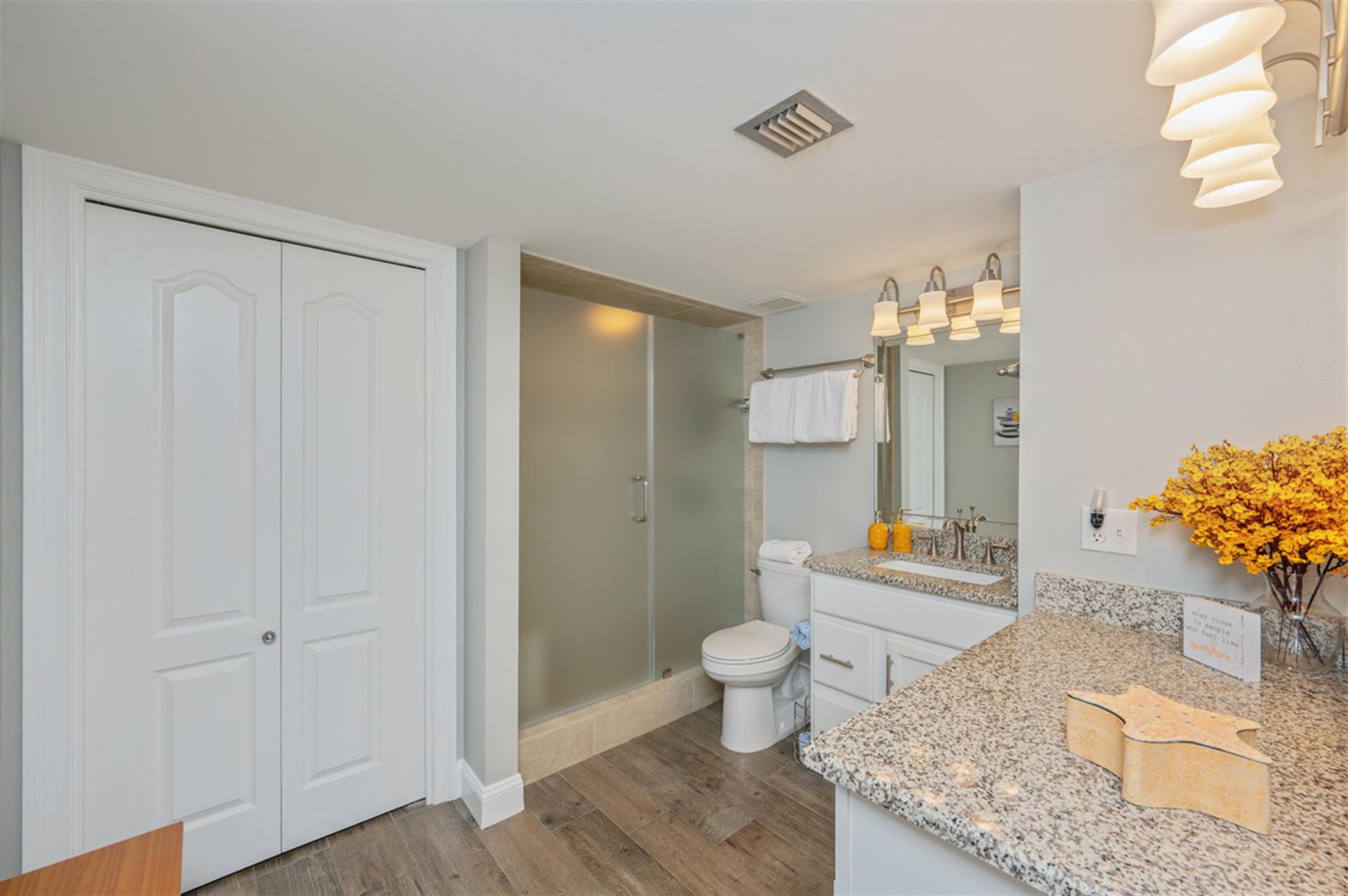Refresh in your spacious bathroom with granite counters, modern shower, and thoughtful touches like fresh flowers welcoming you home.