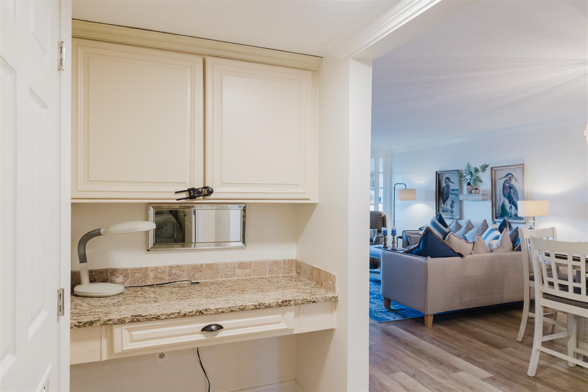 Your elegant kitchenette features granite counters, white cabinetry, and a built-in microwave, flowing seamlessly into the cozy living area.