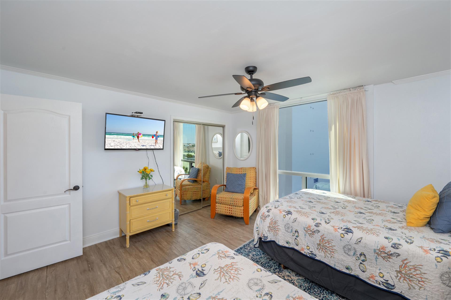 Unwind in your bright, cheerful bedroom with twin beds, cozy seating area, and private balcony access for morning coffee or evening relaxation.