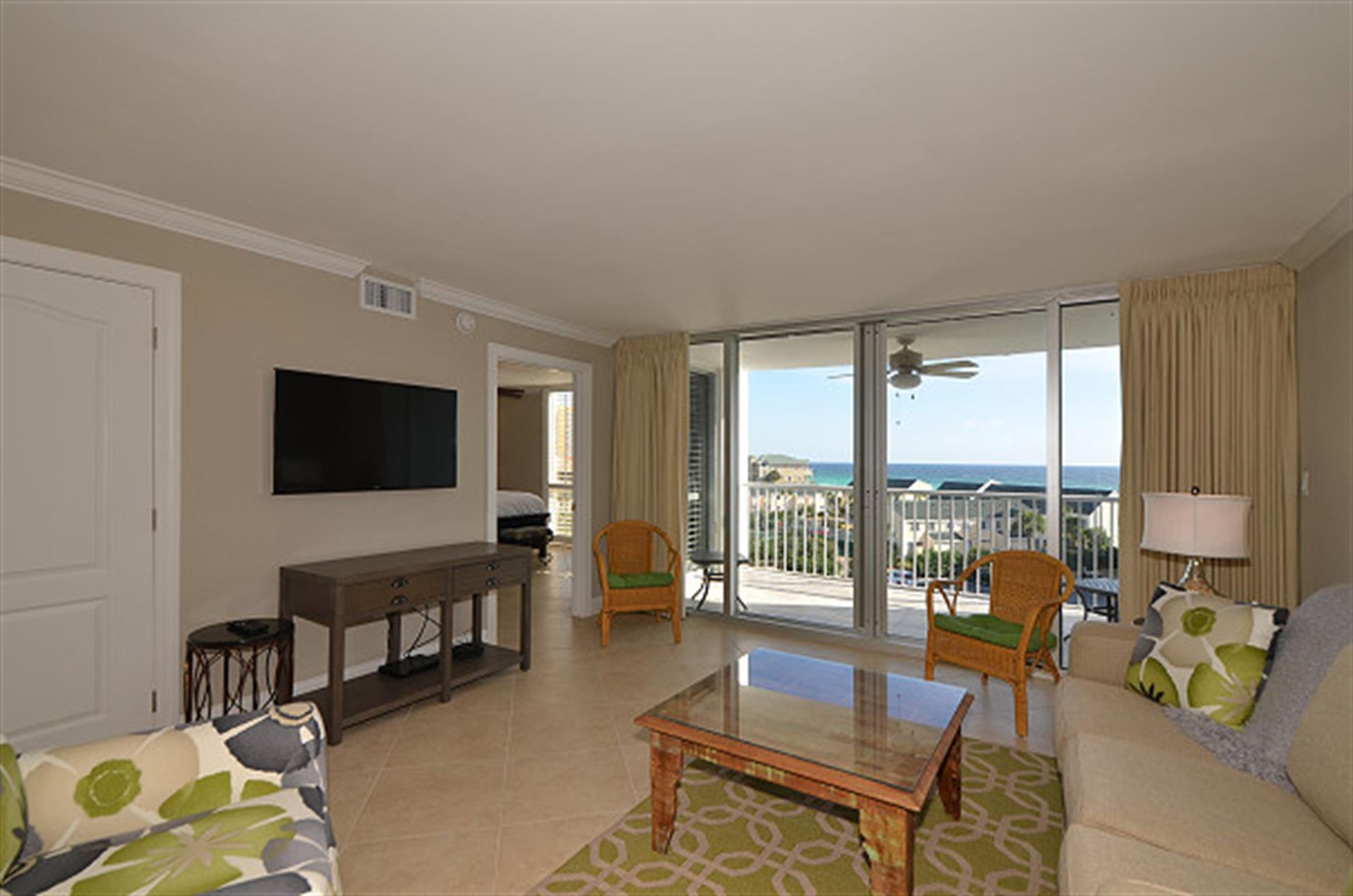 Your bright living room opens to stunning ocean views through floor-to-ceiling windows, with comfortable seating and modern amenities for perfect relaxation.