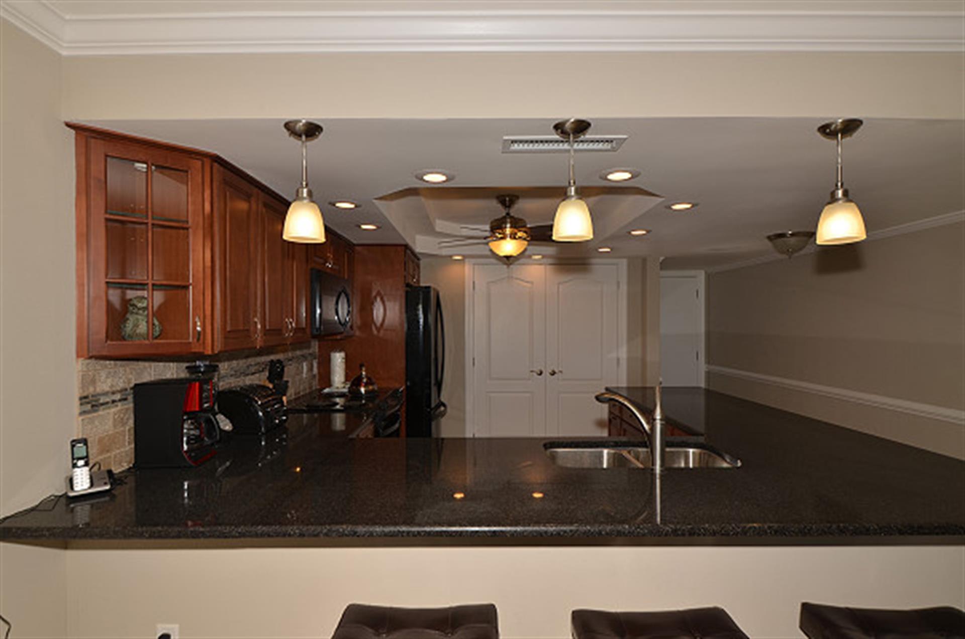 Whip up your favorite meals in this elegant kitchen featuring rich wood cabinetry, granite countertops, and modern appliances.