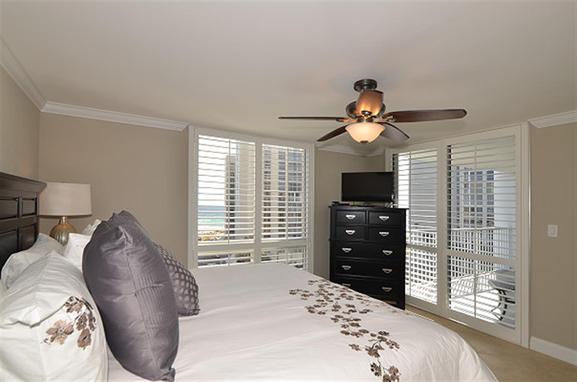 Sleep soundly in your private bedroom with peaceful city views through plantation shutters and gentle ceiling fan breezes.
