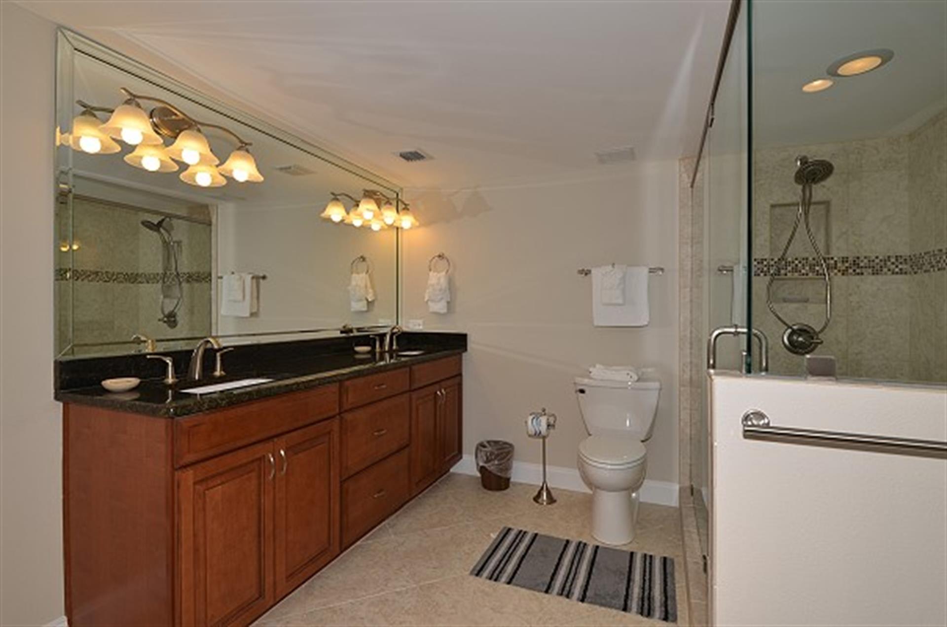 Soak away your day in this elegant master bathroom, featuring a deep soaking tub, separate glass shower, and luxurious granite countertops.