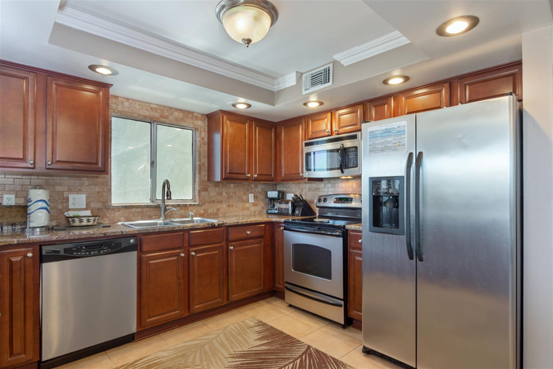 Your fully equipped kitchen awaits with rich cherry cabinets, granite countertops, and stainless steel appliances for all your culinary adventures.