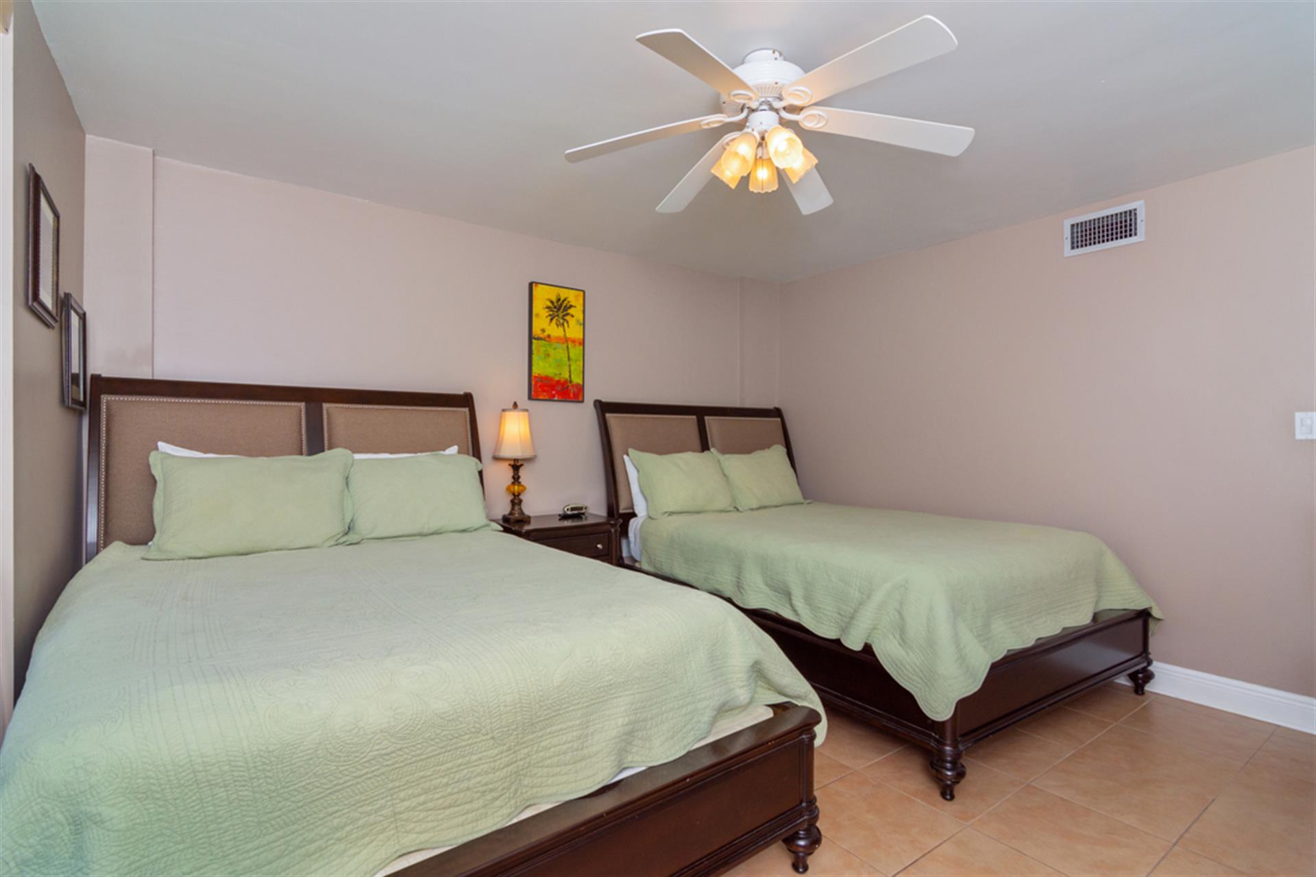 Unwind in your comfortable twin bed setup with crisp linens and tropical breezes from the ceiling fan overhead.