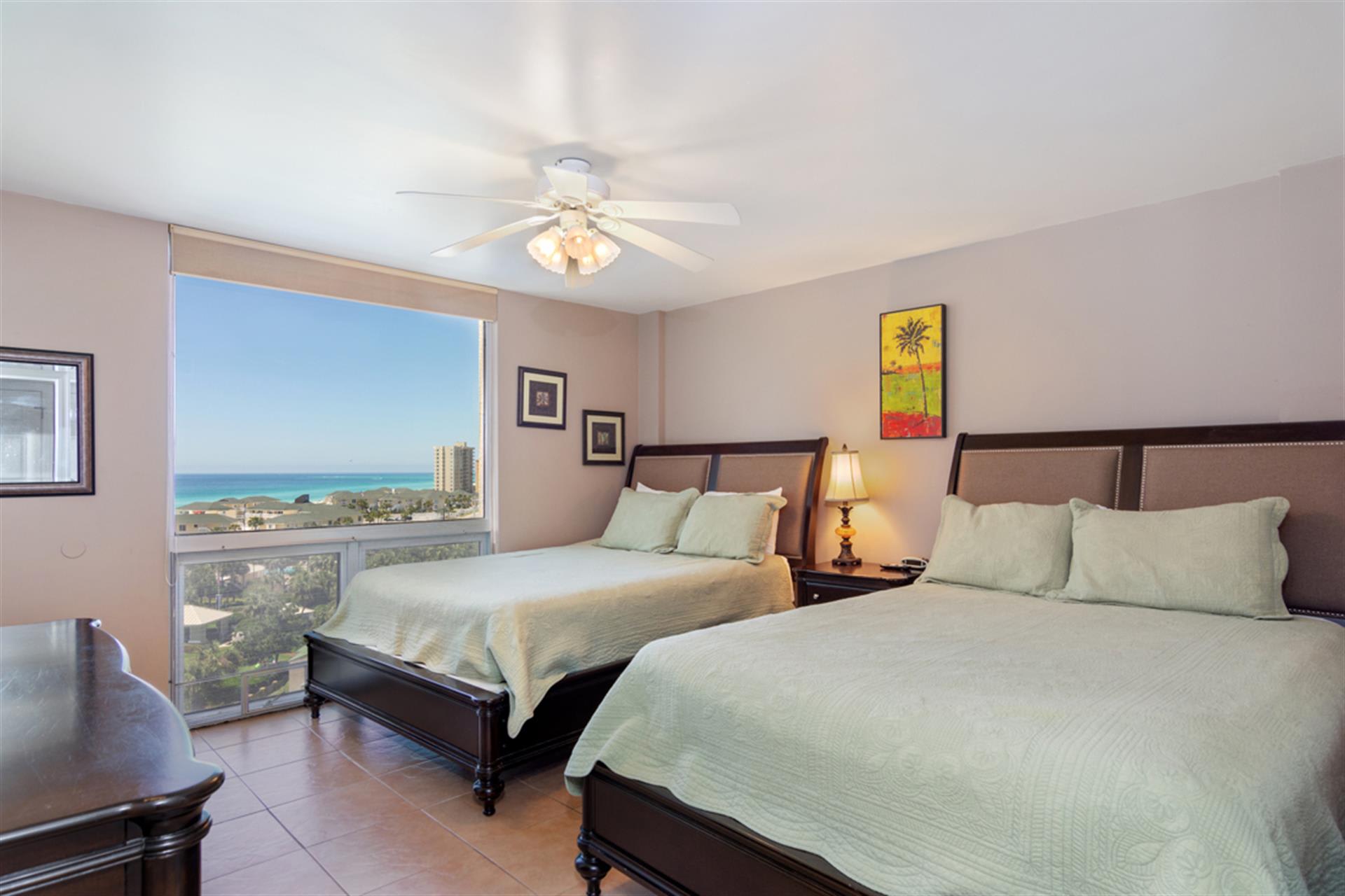 Wake up to stunning ocean views from your comfortable twin beds in this bright, airy bedroom with ceiling fan and coastal decor.