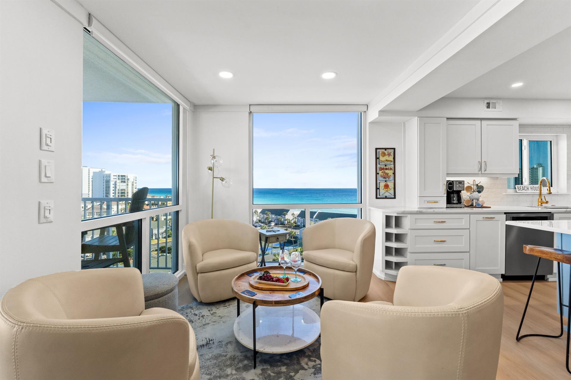 Relax in your stylish living space with stunning ocean views through floor-to-ceiling windows and a modern kitchen at your fingertips.