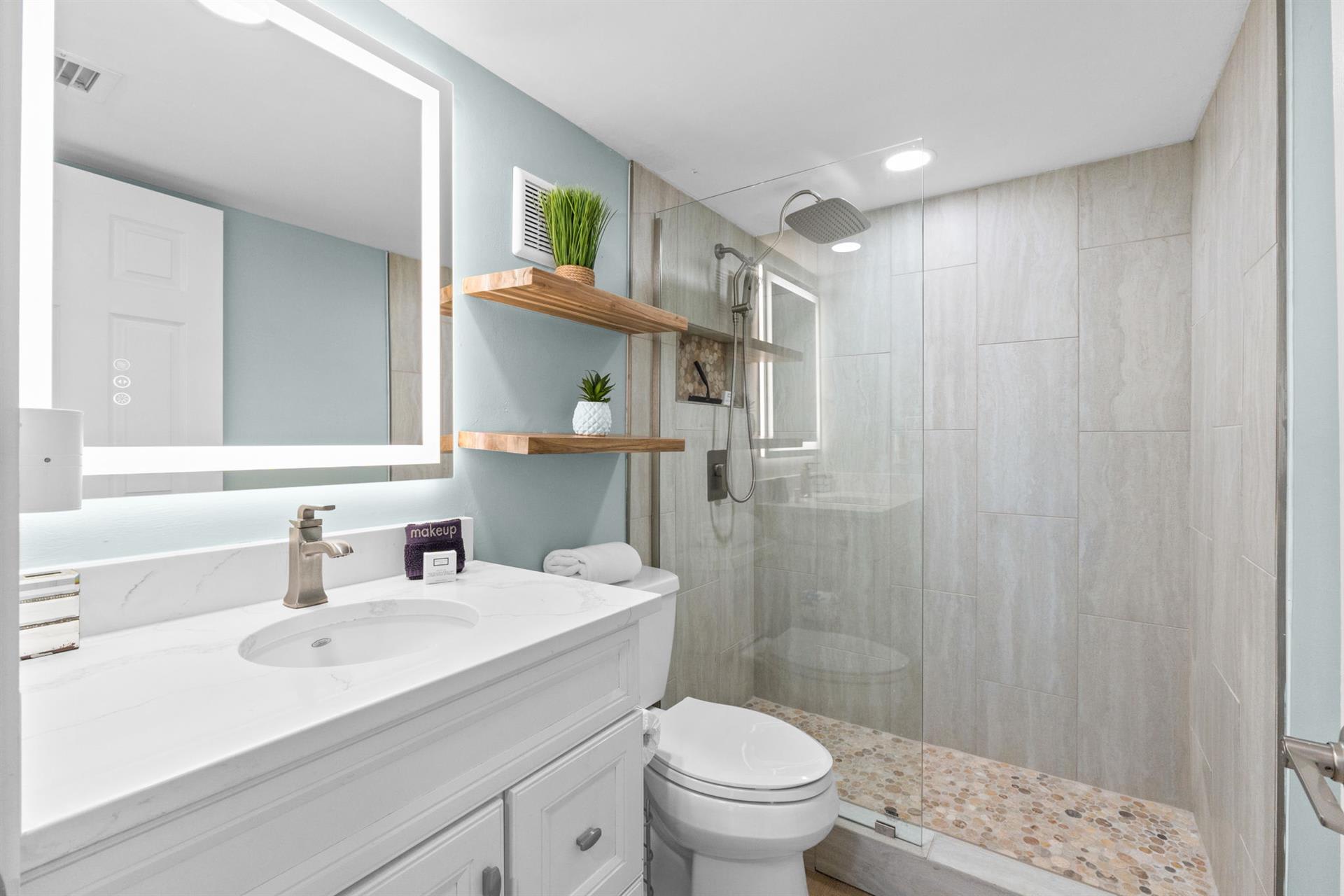 Step into your spa-like ensuite with rainfall shower, floating shelves, and LED-lit vanity for your refreshing morning routine.