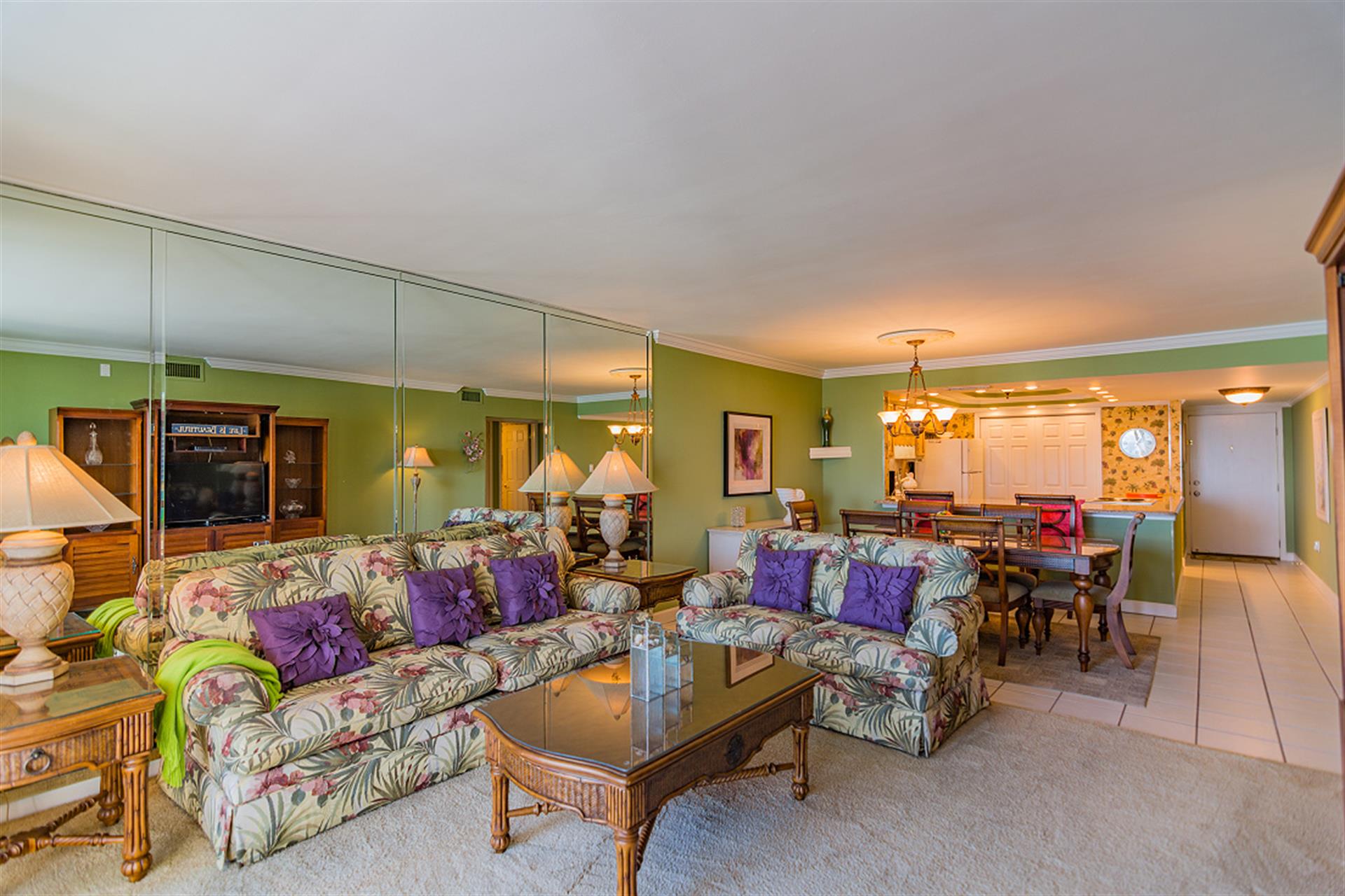 Relax in your tropical-themed living space with vibrant furnishings and open dining area perfect for memorable vacation meals.