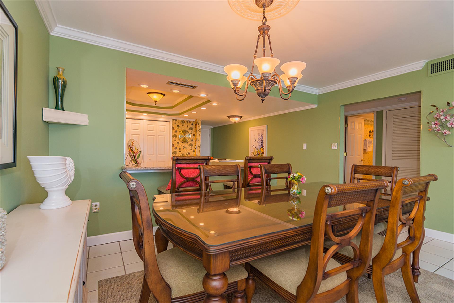 Your elegant dining space features beautiful green walls, warm chandelier lighting, and seating for memorable meals together.