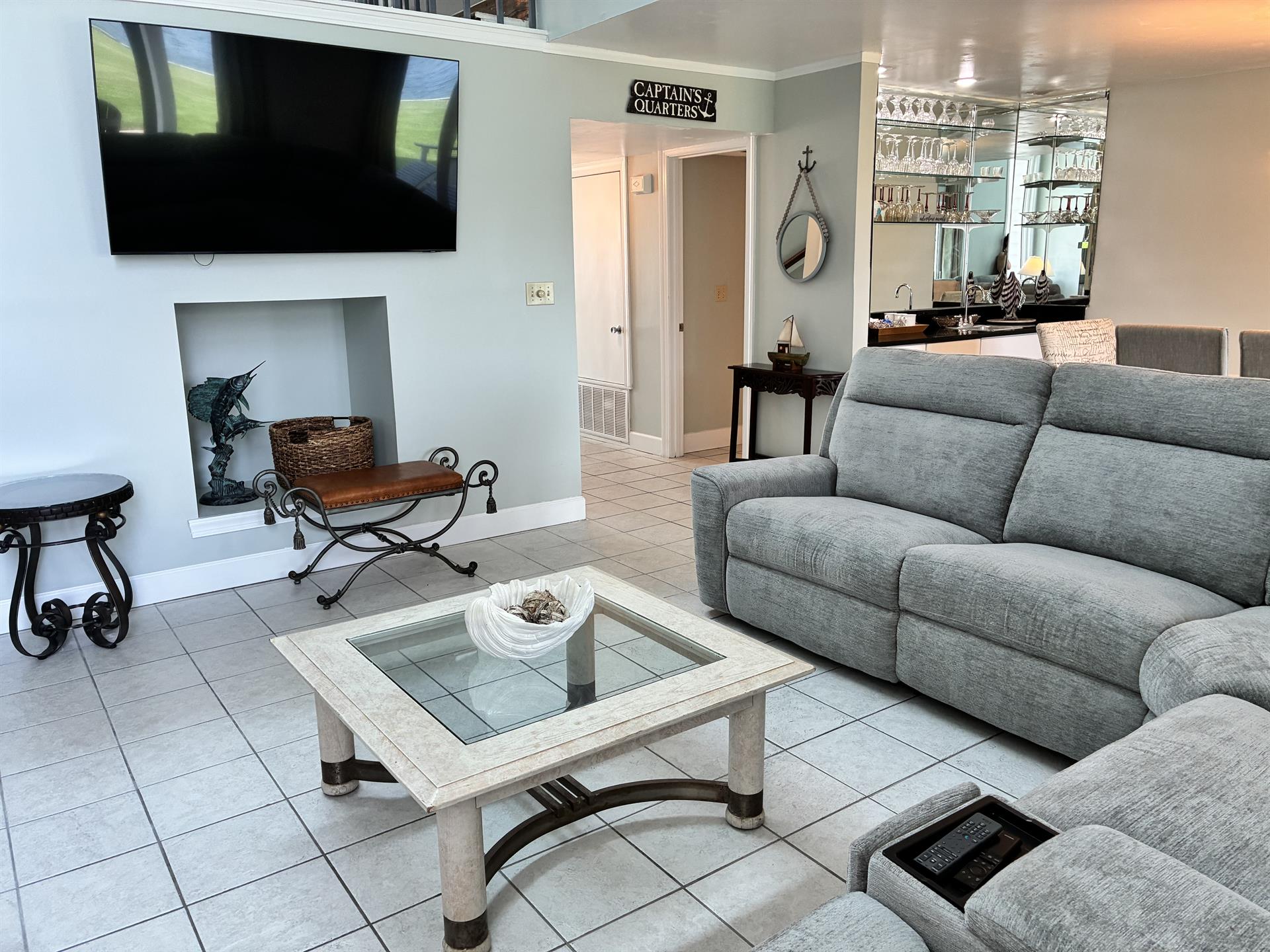 Your nautical-themed retreat features plush seating, a large flat-screen TV, and a warm fireplace for cozy evenings.