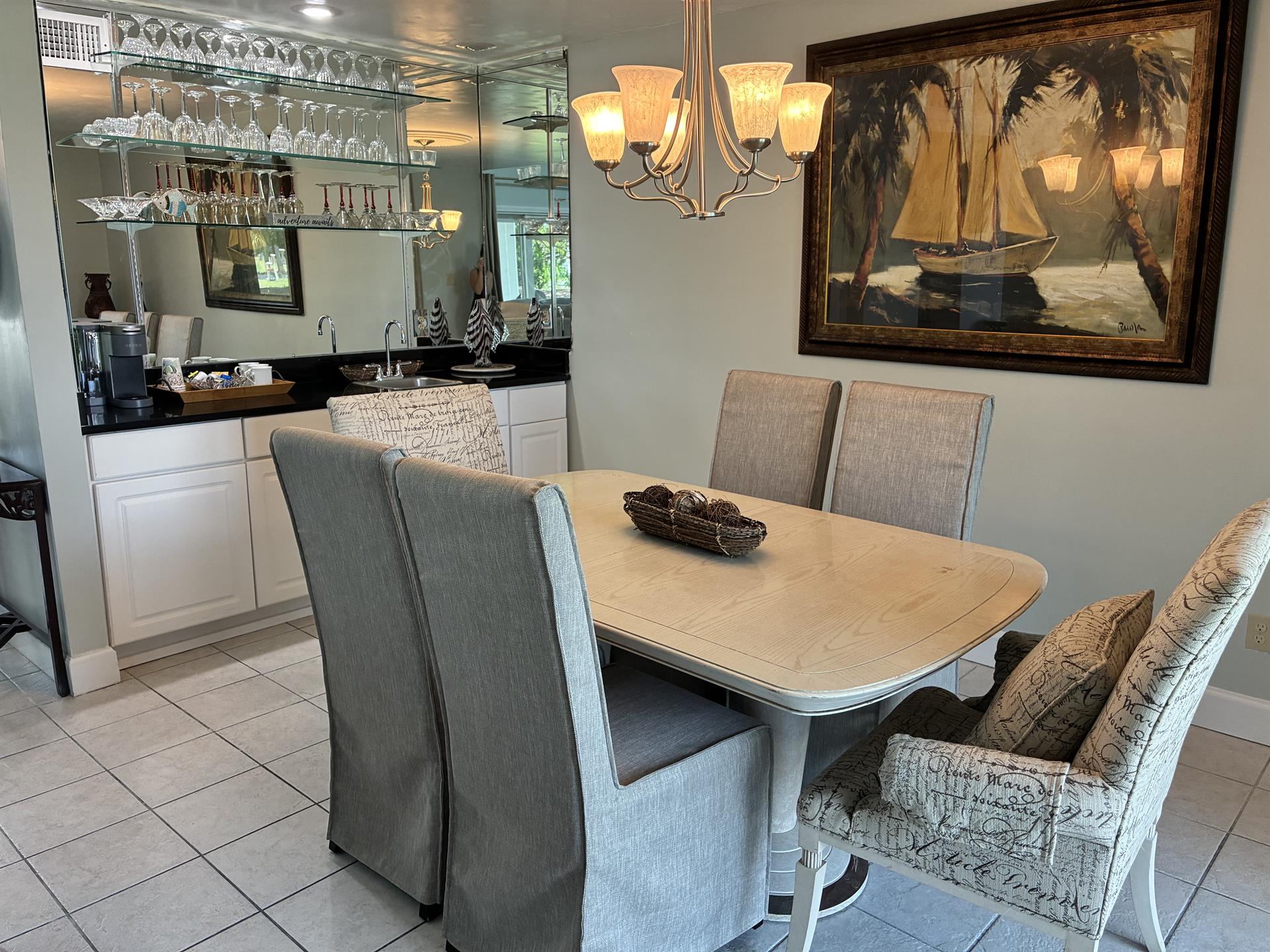 Gather around your elegant dining table for memorable meals while admiring nautical artwork and sparkling glassware displays.