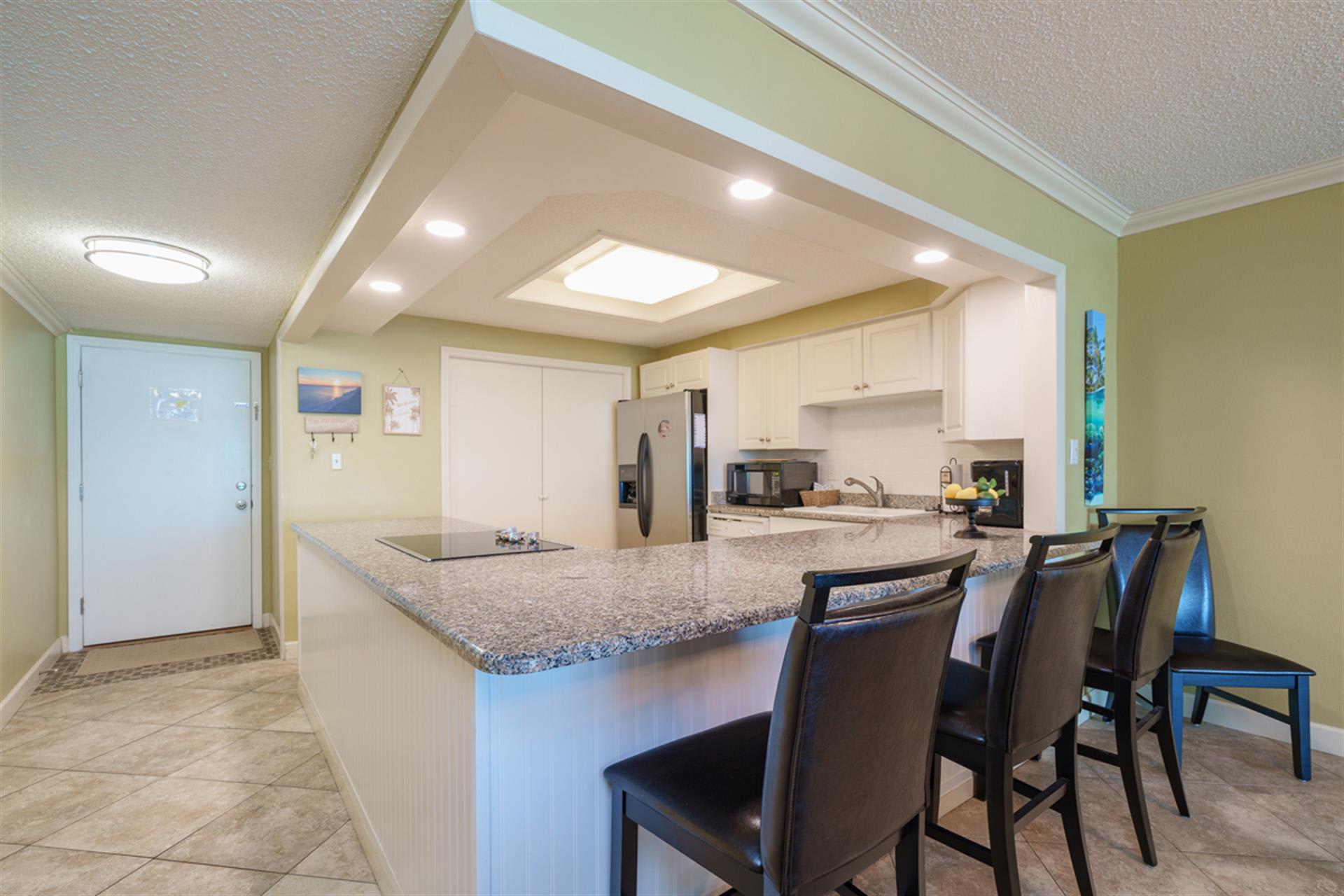 Your sleek kitchen island beckons with granite countertops and breakfast bar seating, perfectly positioned beneath elegant recessed lighting.