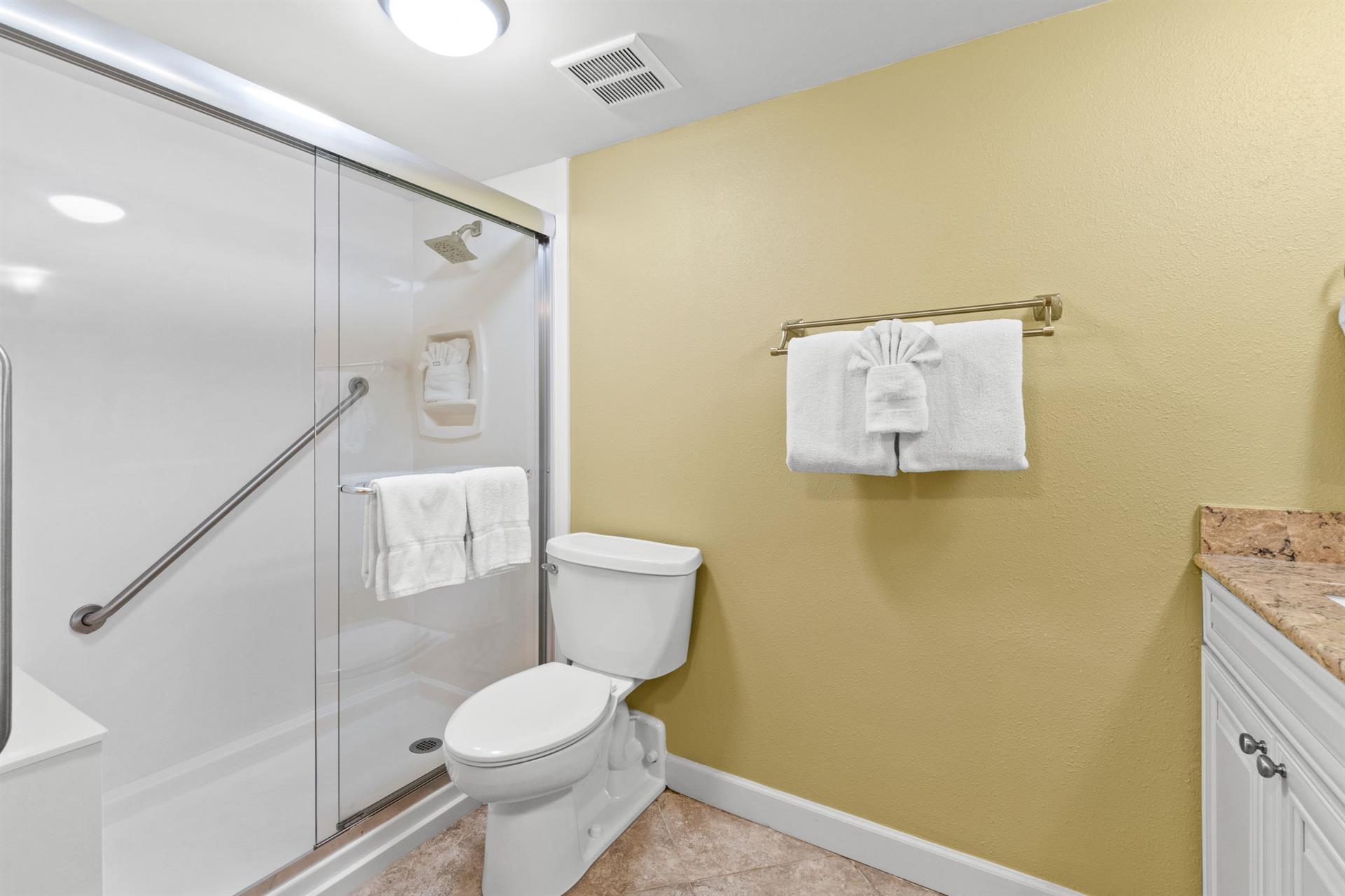 Your private bathroom features a spacious walk-in shower, fresh towels, and thoughtful accessibility features for your comfort.