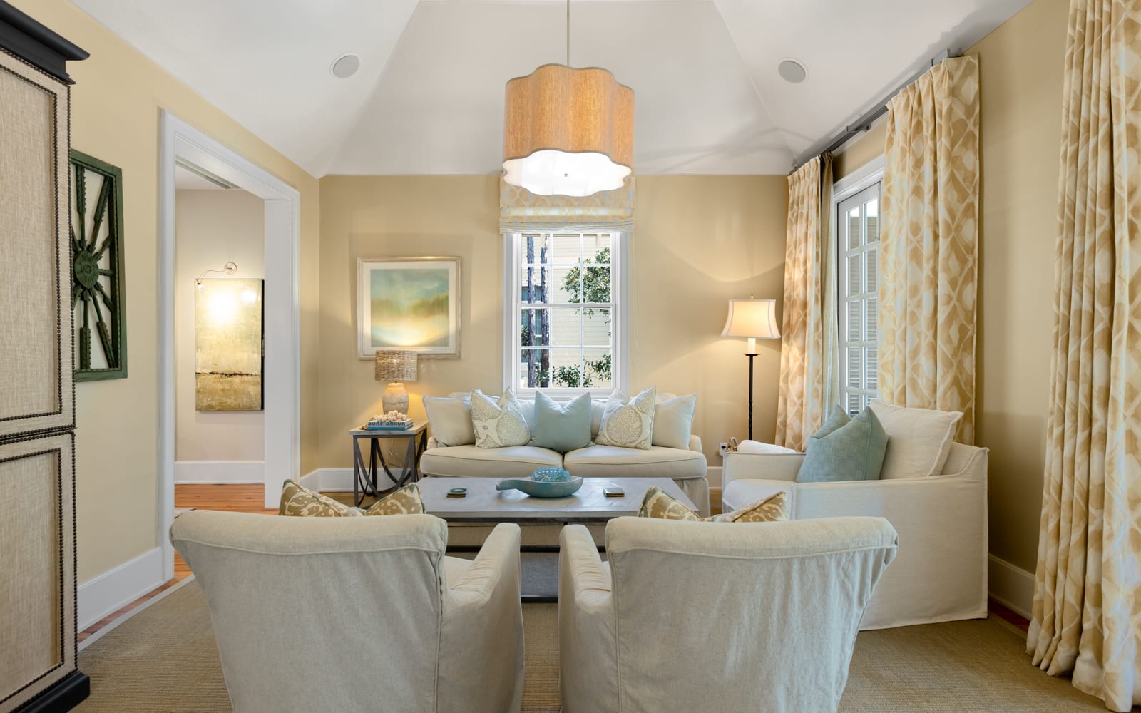 Your elegant living room awaits with plush seating, warm lighting, and peaceful views through tall windows.