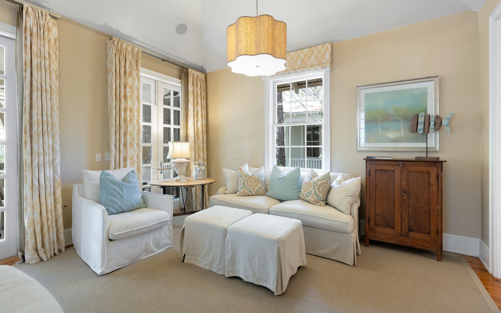 Sink into plush seating in your elegant living room, where soft blue pillows complement cream sofas under warm pendant lighting.