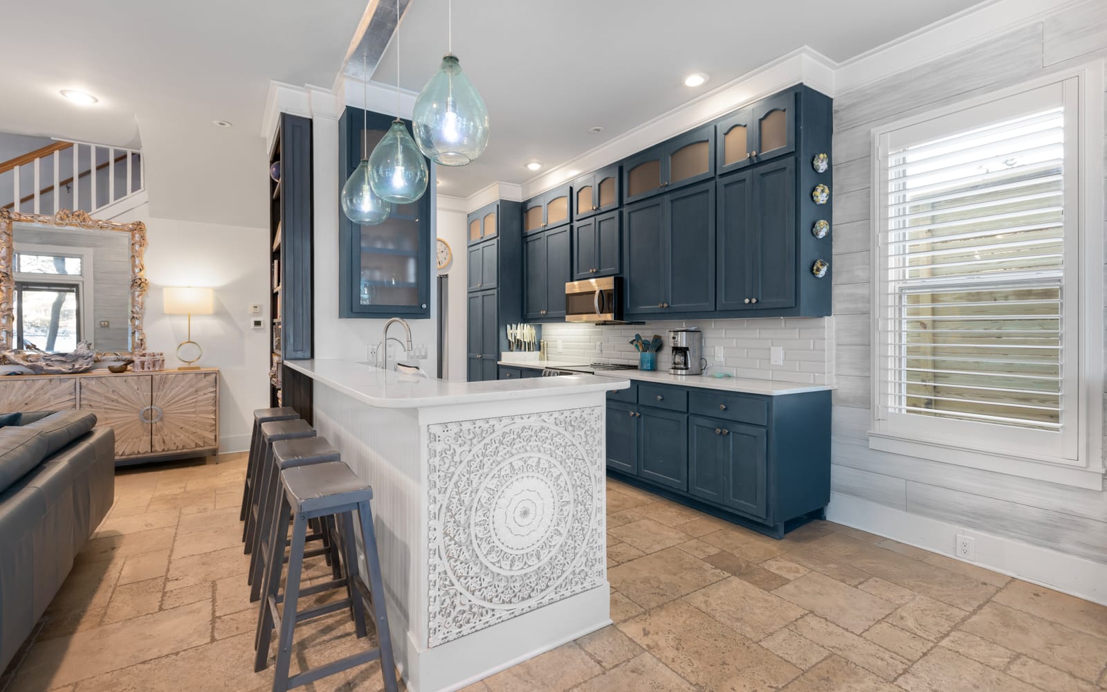 Your gourmet kitchen awaits with sleek navy cabinets, marble countertops, and pendant lighting creating the perfect space for culinary adventures.