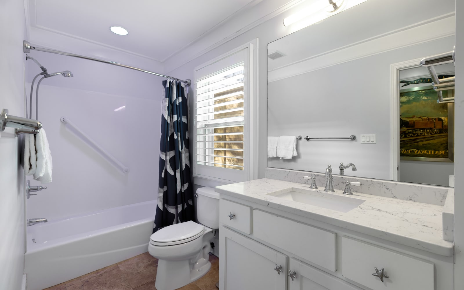 Your beautifully renovated bathroom features marble countertops, fresh white cabinetry, and a relaxing tub-shower combo for your comfort.