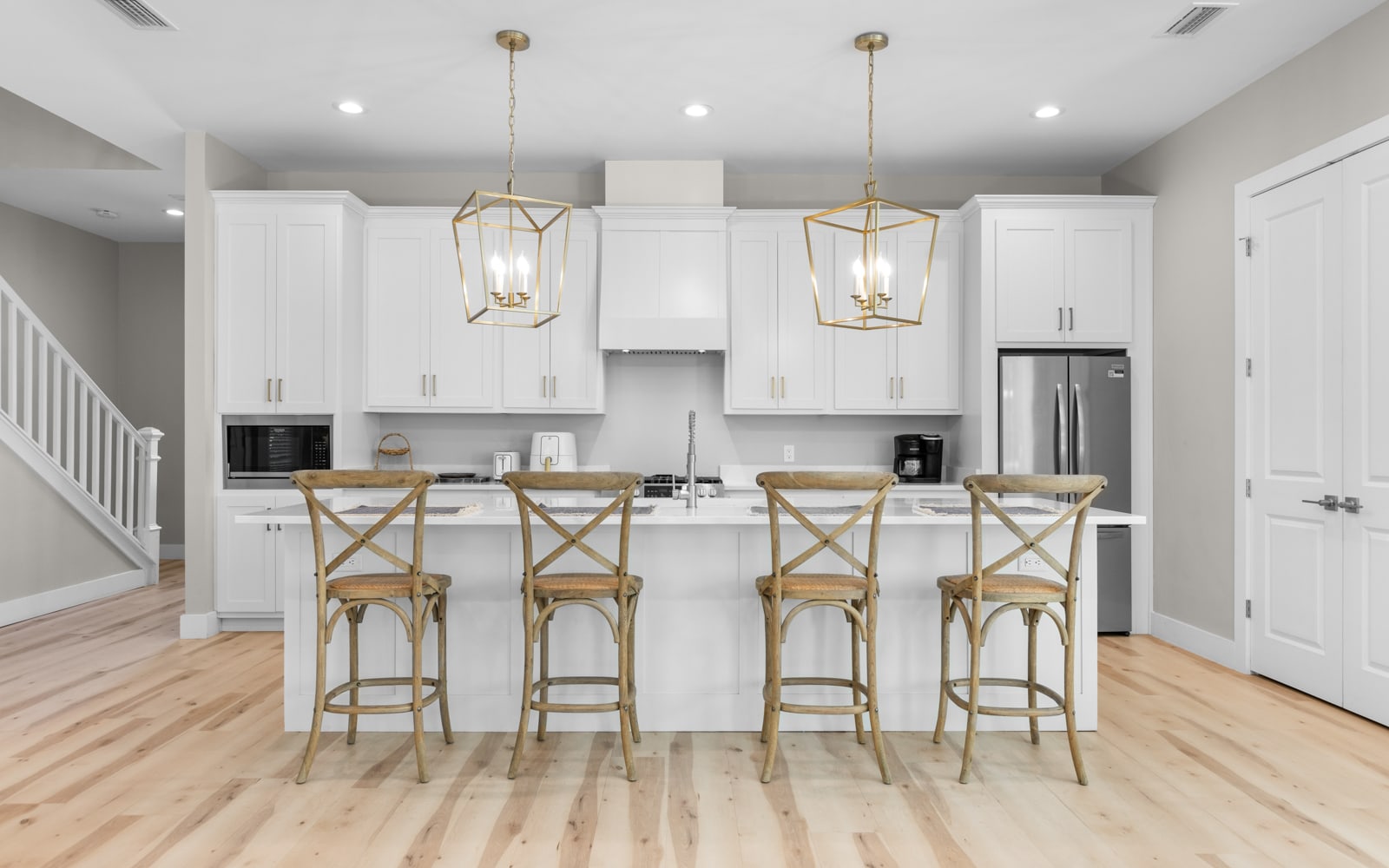 Your bright kitchen awaits with gleaming white cabinets, marble countertops, and cozy breakfast bar seating for four.