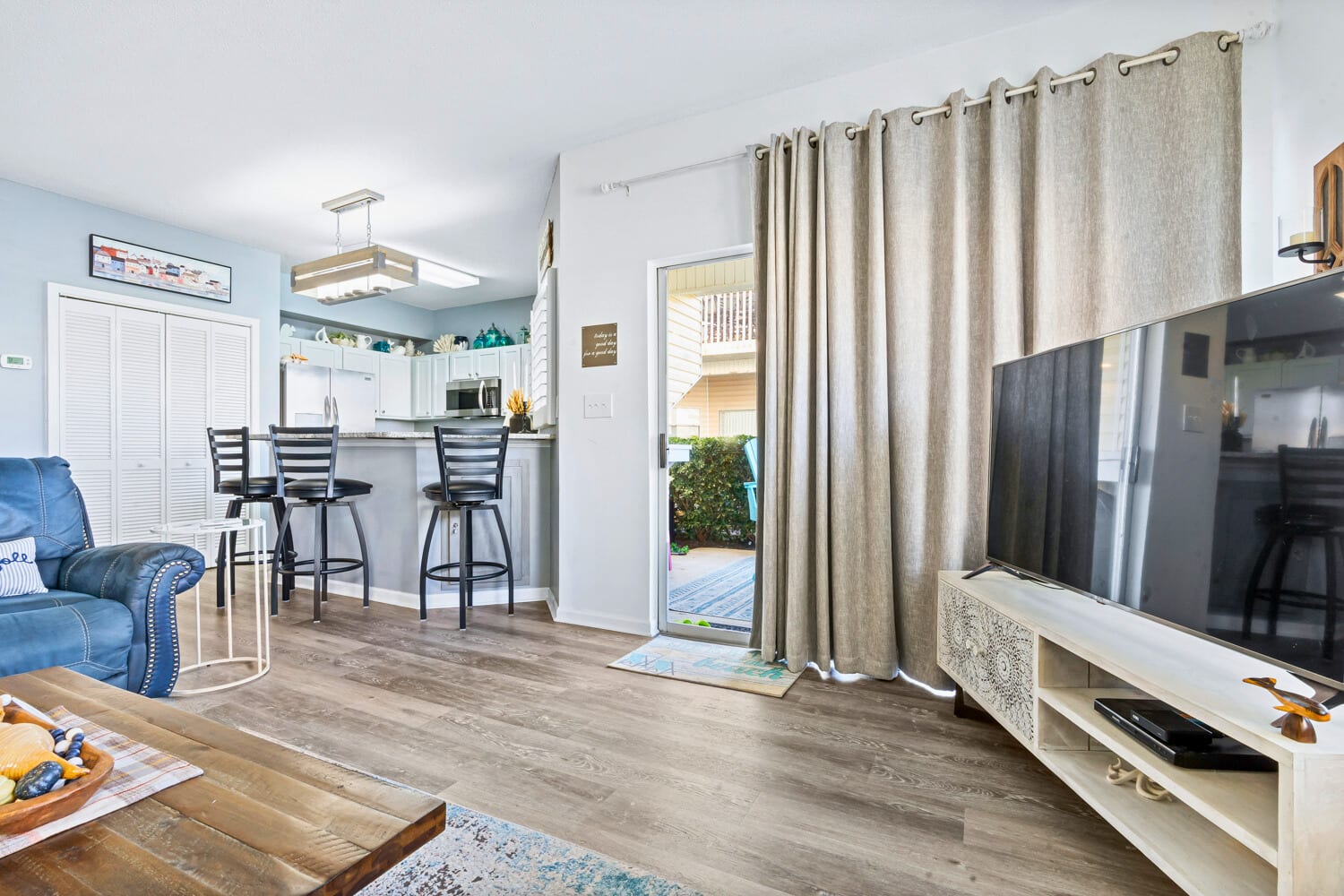 Relax in your bright open-plan living space with modern kitchen, cozy seating, and sliding door access to your private outdoor area.