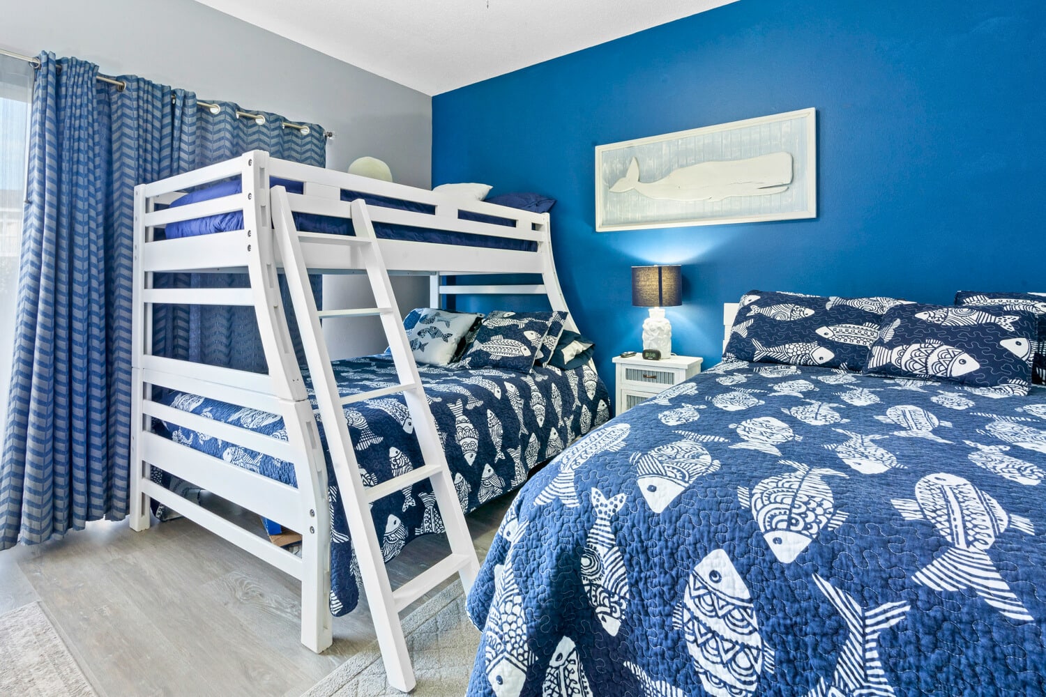 Drift off in this ocean-themed bedroom where nautical blues wrap you in seaside serenity and cozy bedding promises restful nights.