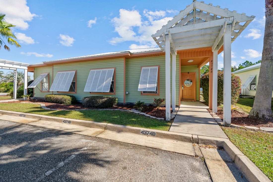 Charming vacation rental with tropical landscaping and welcoming covered entrance in a peaceful residential setting.