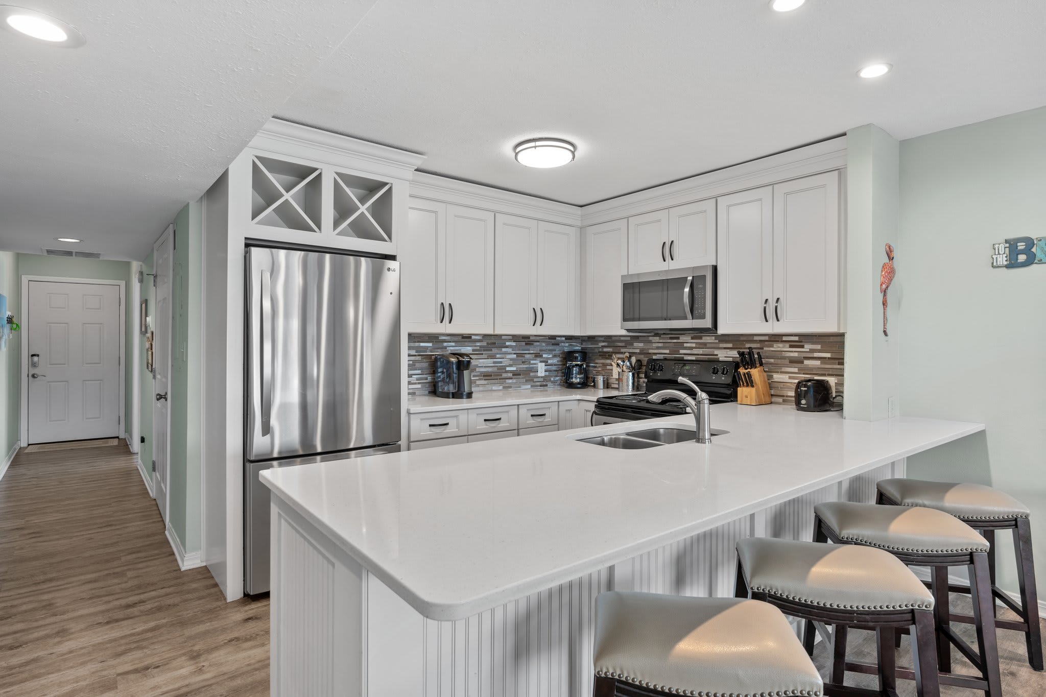 Kitchen with granite countertops, modern cabinetry, full-size refrigerator, oven, microwave, and dishwasher