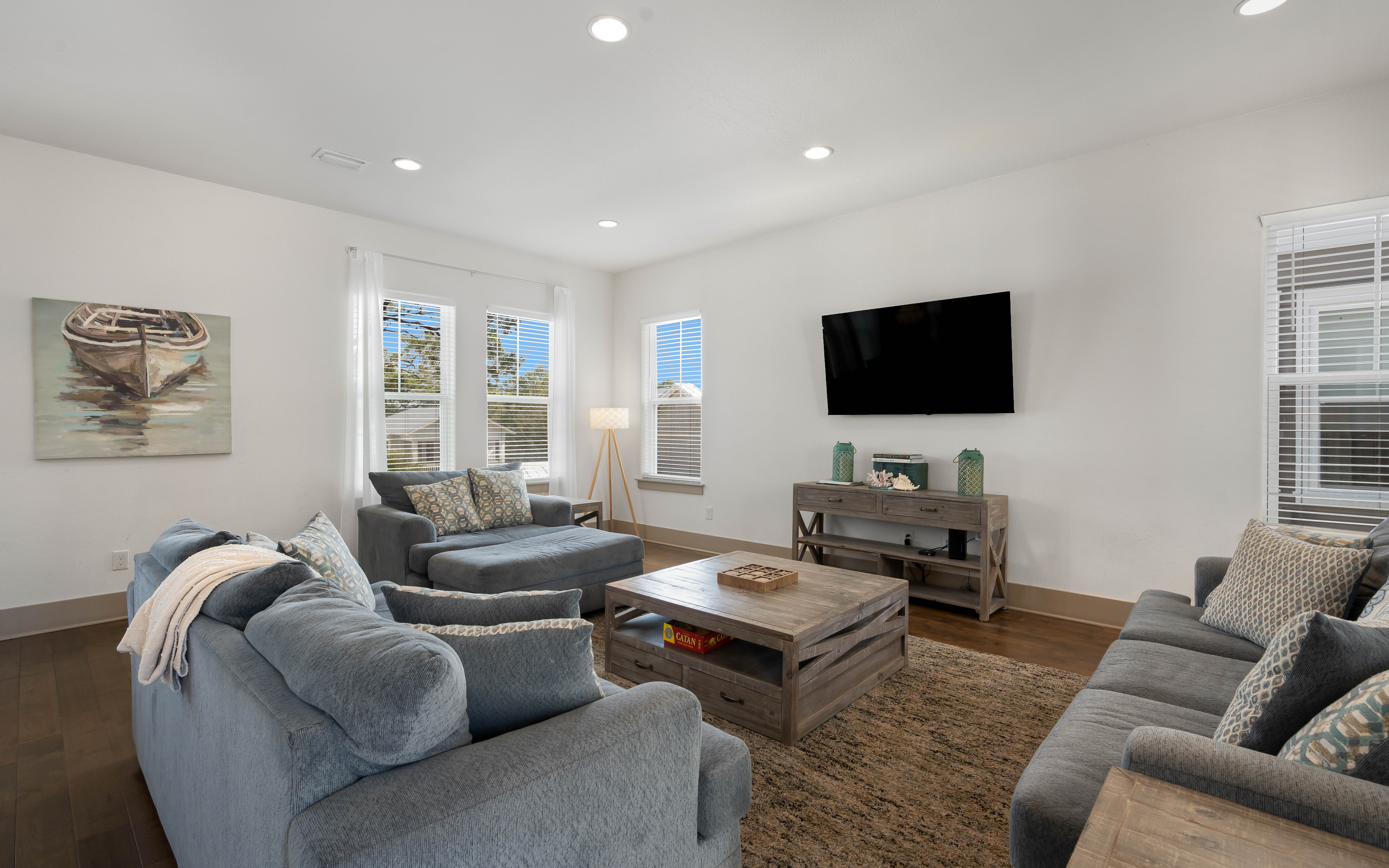 Sink into plush sofas while watching your favorite shows on the wall-mounted TV in this bright, coastal-inspired living space.