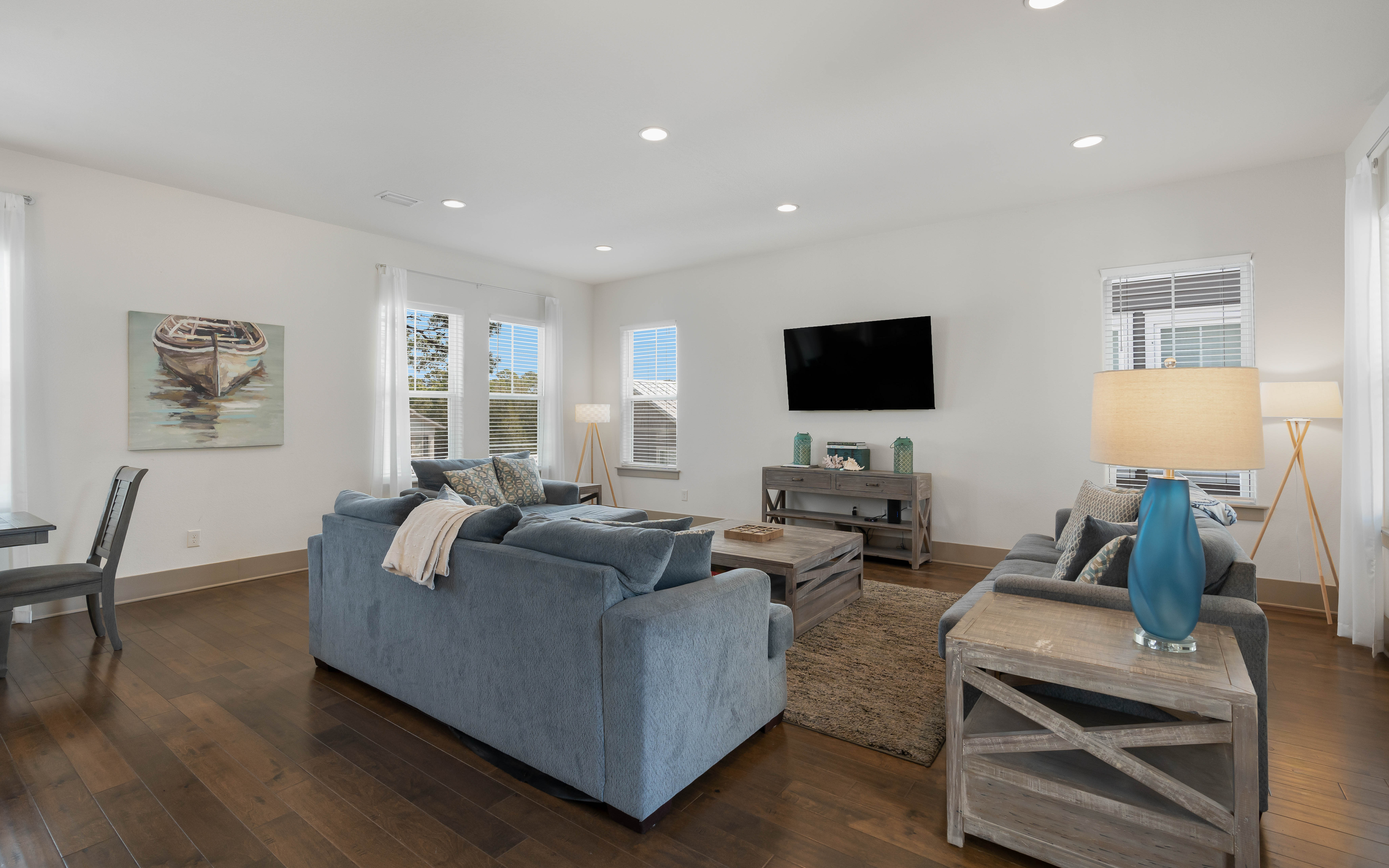 Sink into plush blue sofas and unwind in your bright, modern living space with entertainment ready.