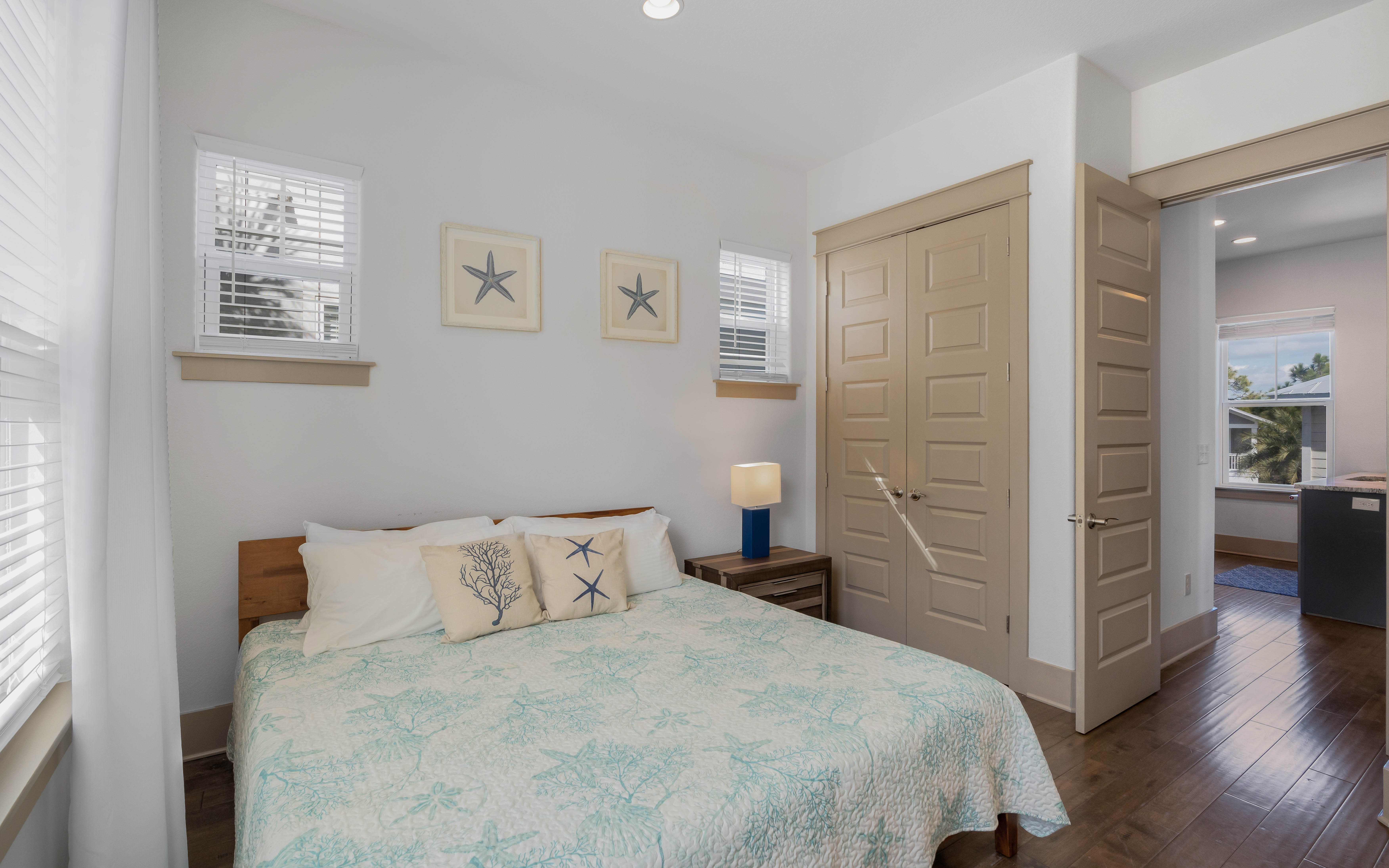 Your coastal-themed bedroom awaits with nautical artwork, soft bedding, and abundant natural light creating a peaceful retreat for restful nights.