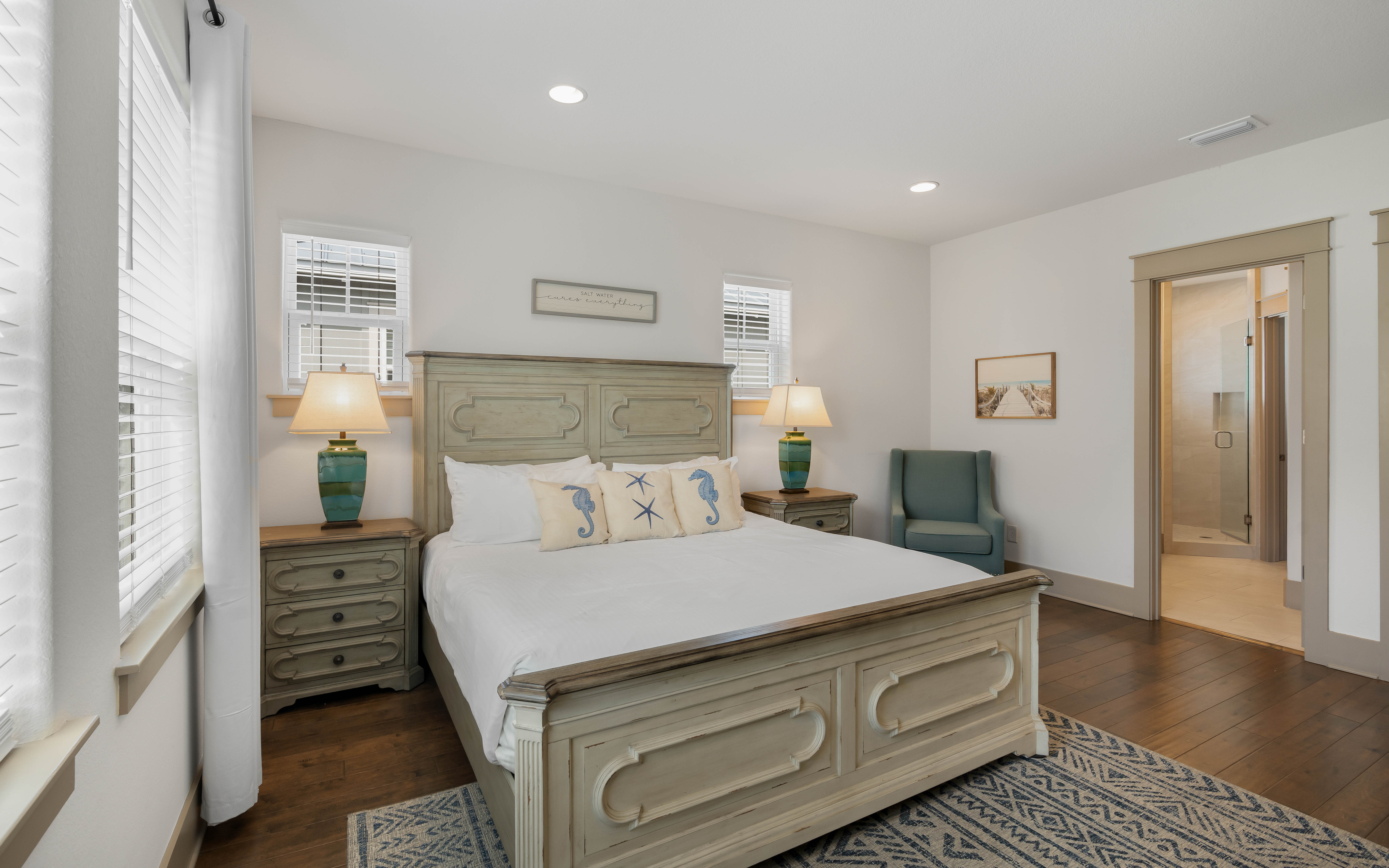 Your coastal bedroom features distressed wood furniture, soft seahorse pillows, and nautical touches that create a serene seaside retreat.