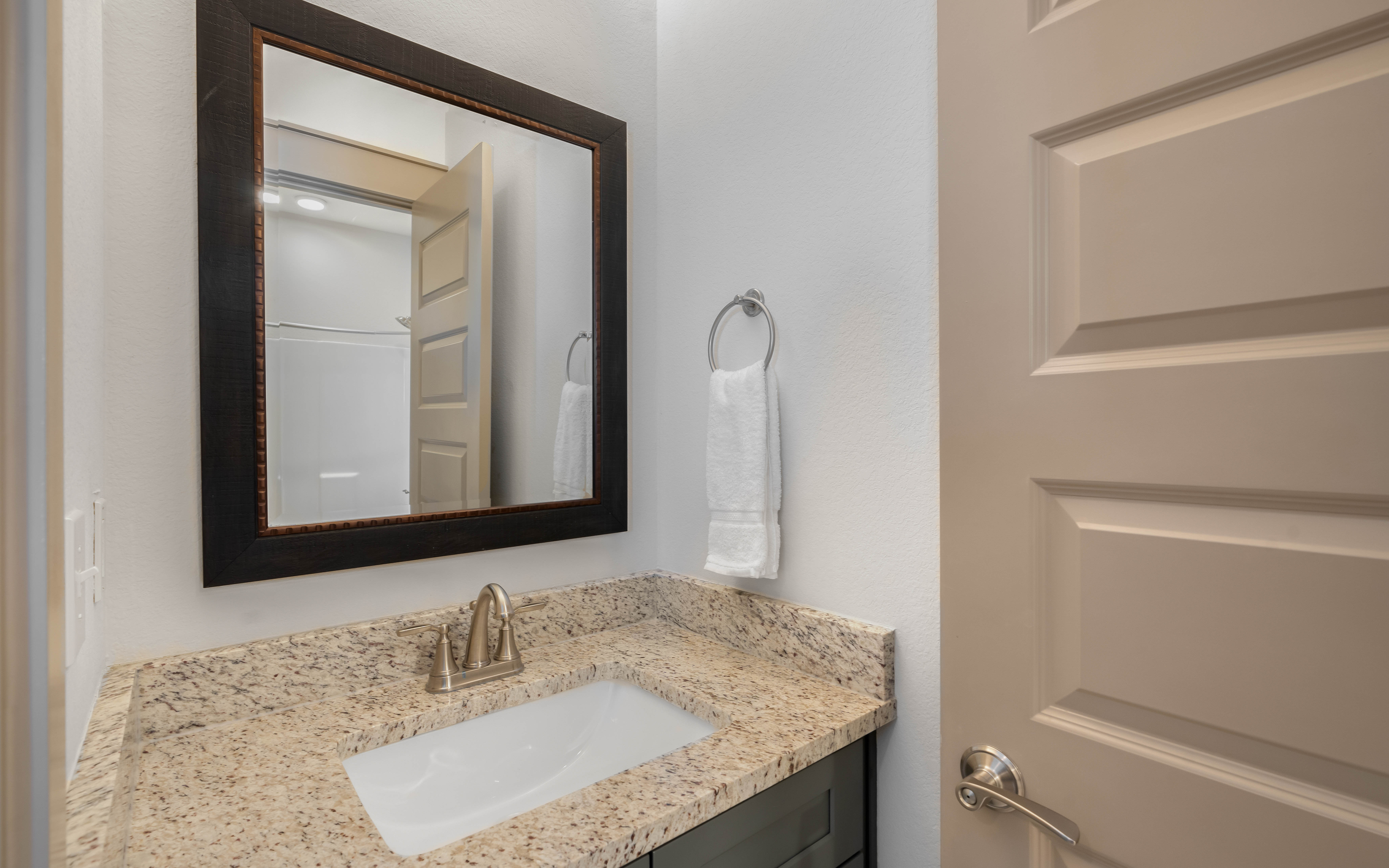Your private bathroom vanity features granite countertops and fresh towels, creating a refined space for your morning routine.