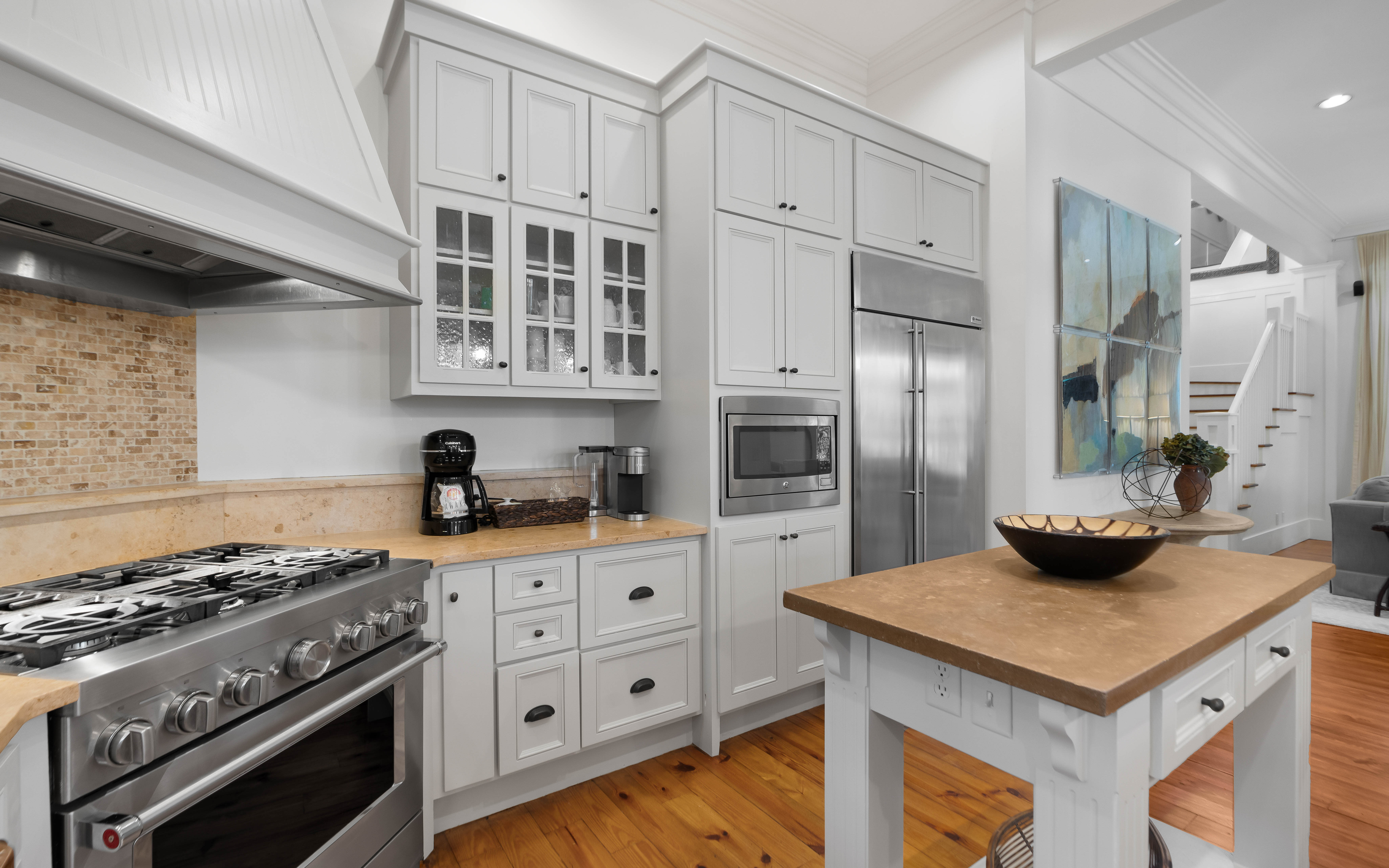 Your dream kitchen awaits with warm wood countertops, professional-grade appliances, and charming white cabinetry perfect for creating memorable meals.