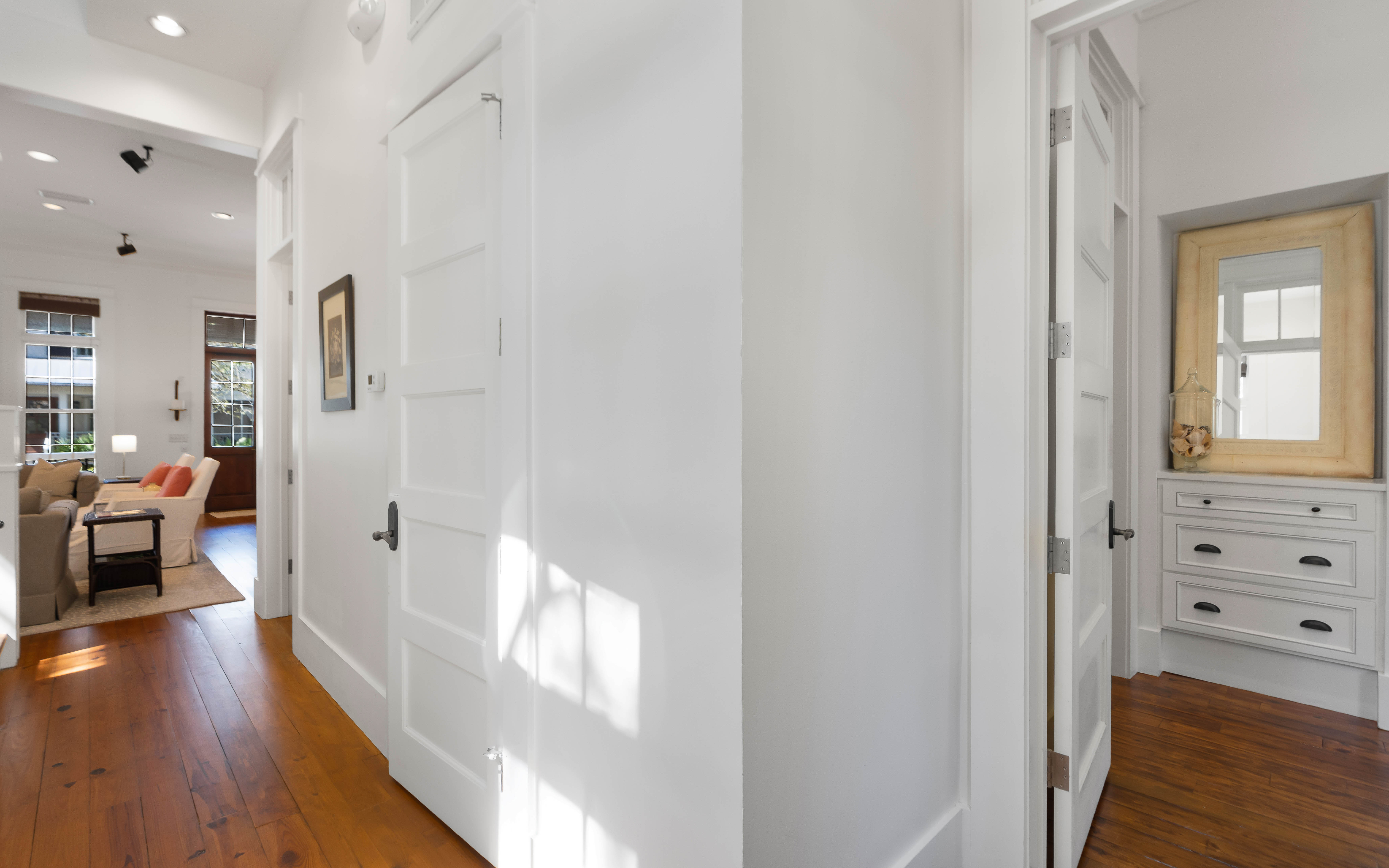 Step into this bright, welcoming hallway where rich hardwood floors guide you through your spacious home away from home.