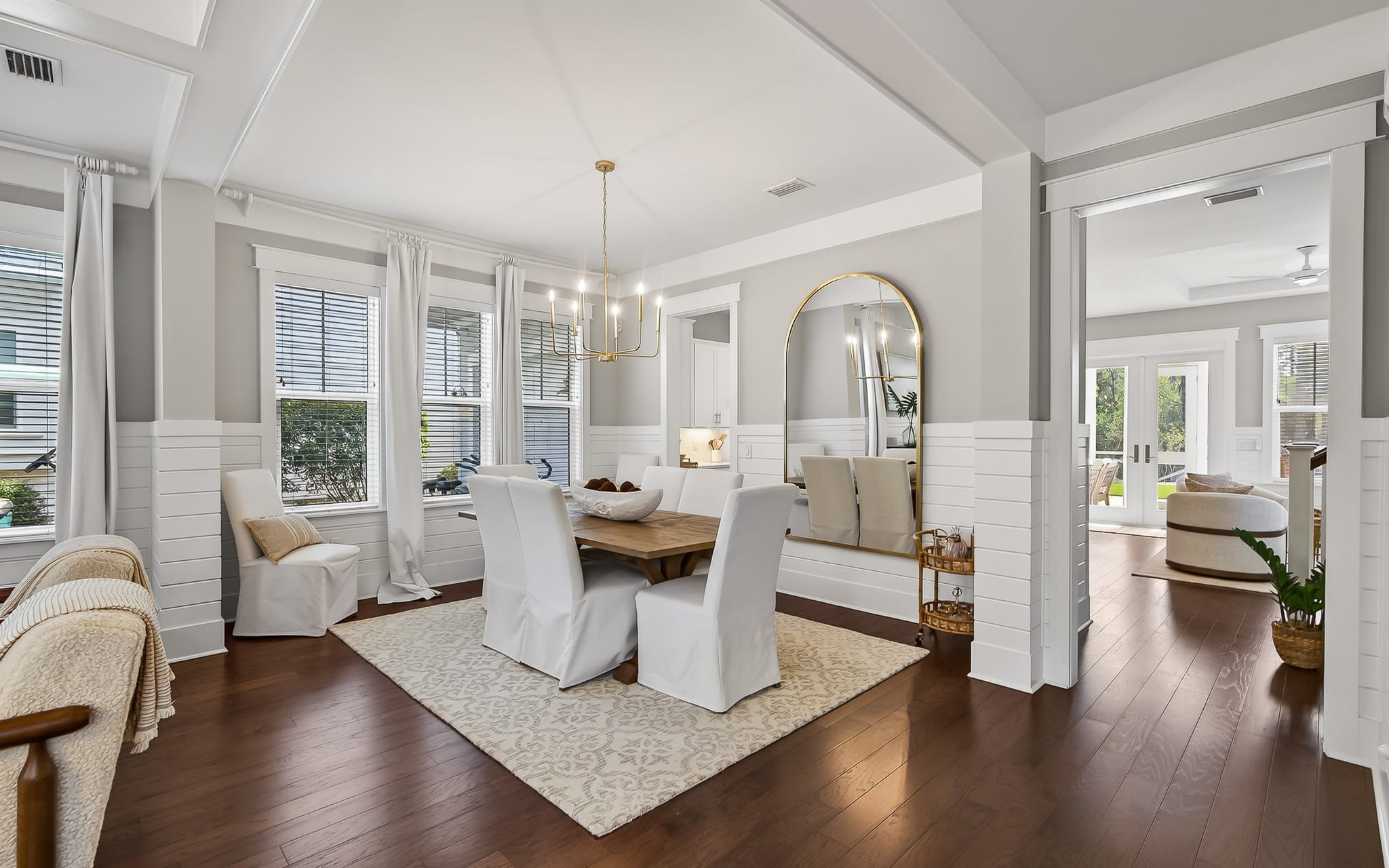 You'll love gathering around this elegant dining table, where natural light streams through large windows as you enjoy meals together.