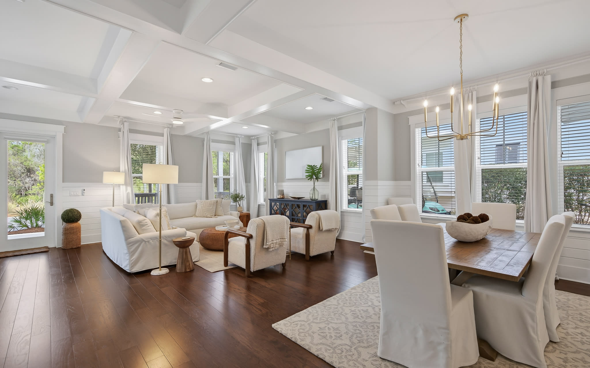 Sink into luxurious comfort in your elegant living space, where soaring coffered ceilings and warm hardwood floors create an inviting atmosphere for relaxation and memorable gatherings.