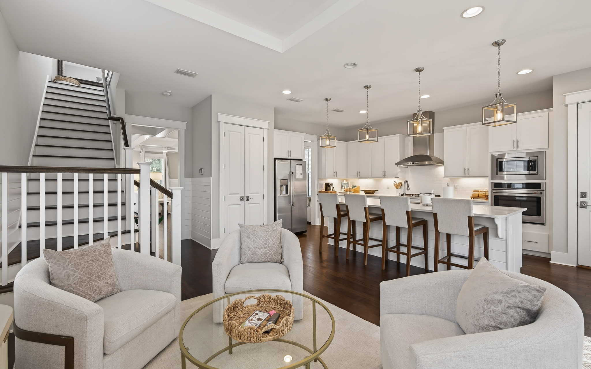 Your open-concept living seamlessly connects kitchen and lounge with sleek pendant lights, cozy seating, and modern appliances for effortless entertaining.