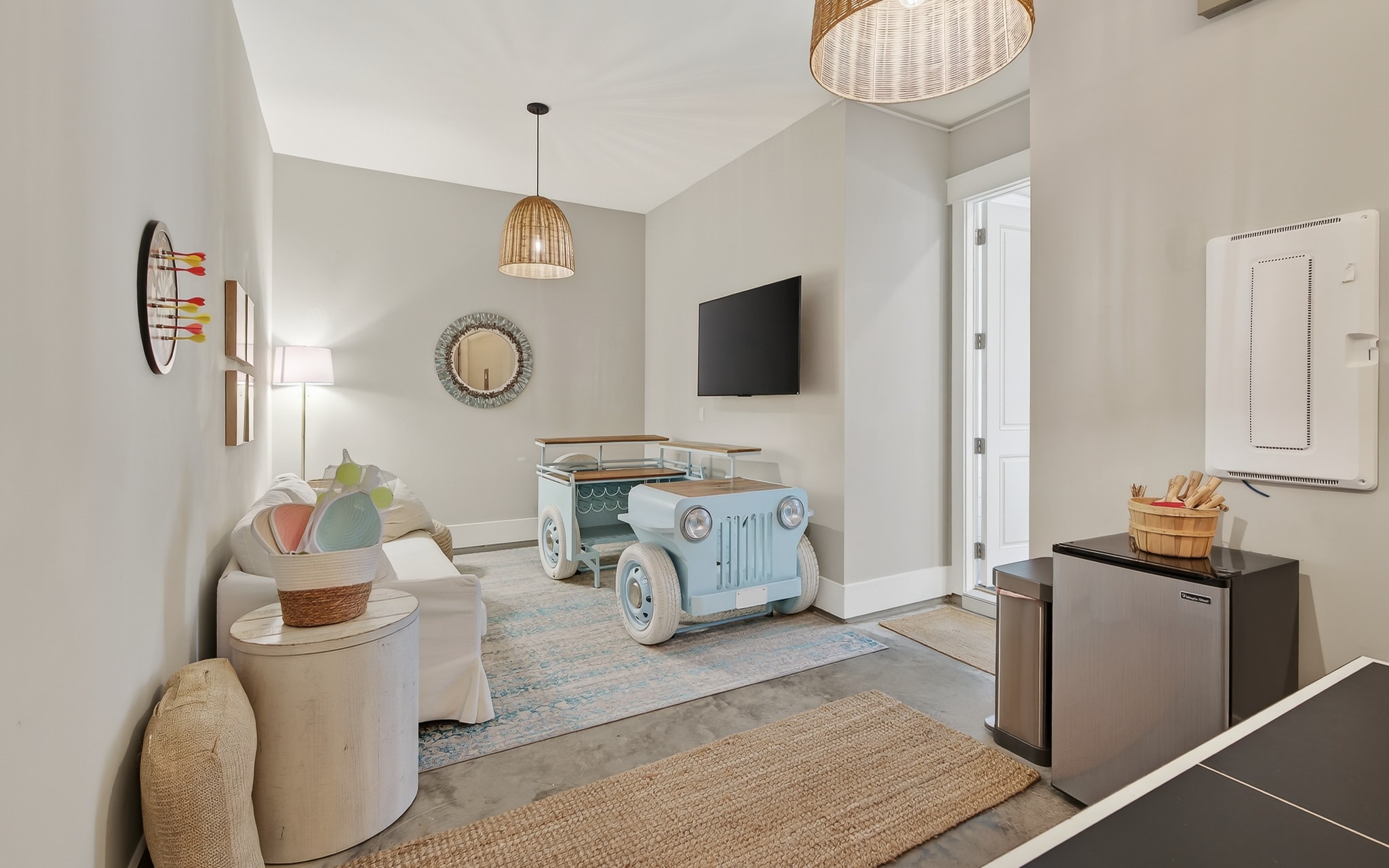 You'll love this playful living space with unique vintage car coffee table, cozy seating, and modern amenities for your perfect getaway.