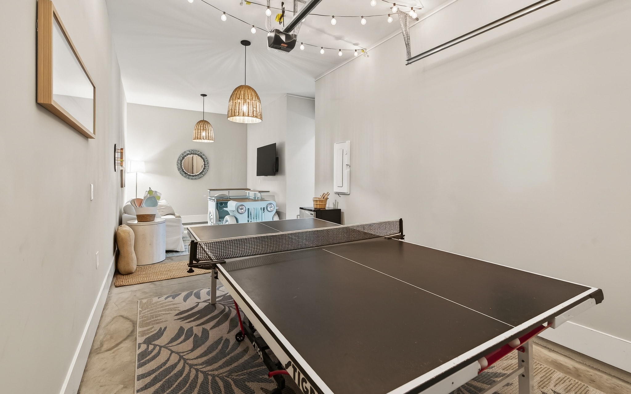 Challenge friends to ping pong in your stylish game room, complete with wicker pendant lights and cozy seating nearby.