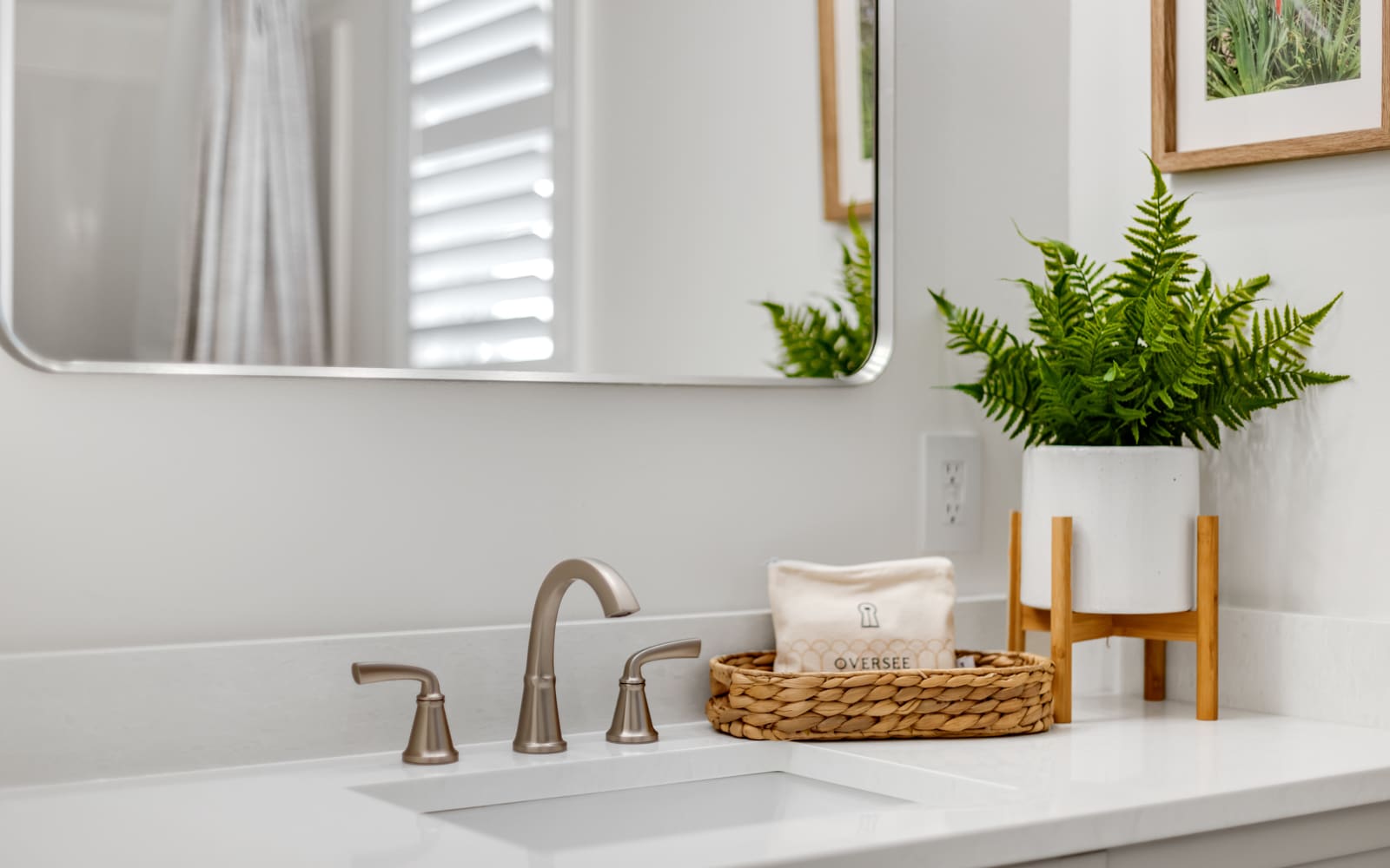 Freshen up in your stylishly appointed bathroom featuring a gleaming vanity, elegant fixtures, and thoughtful touches like fresh greenery.